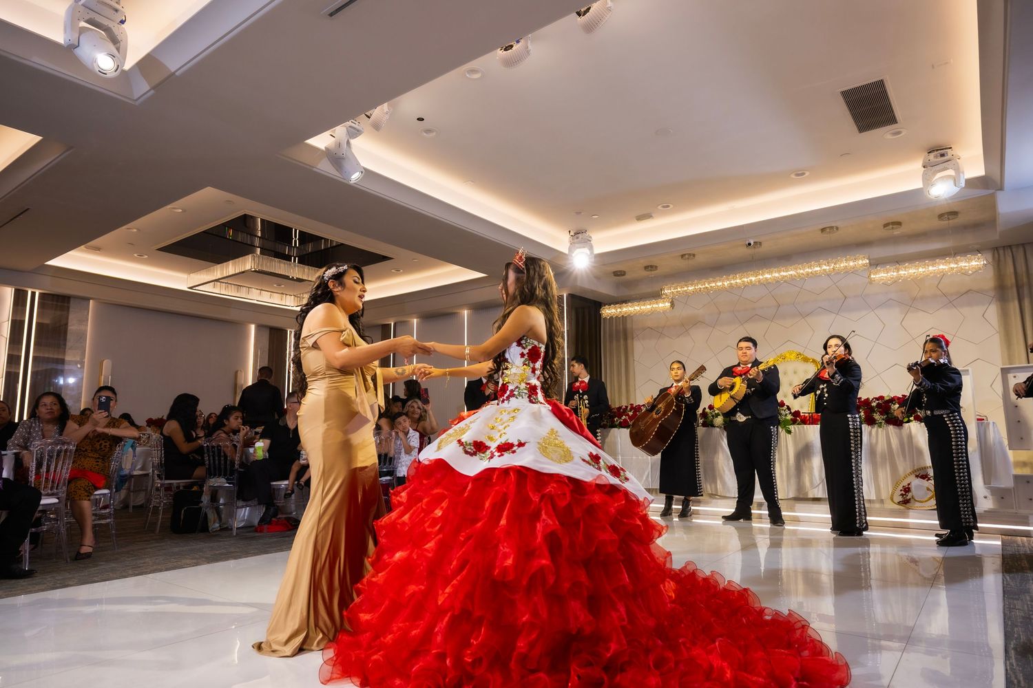 A group of dancers practicing on a shiny dance floor in a bright studio space.