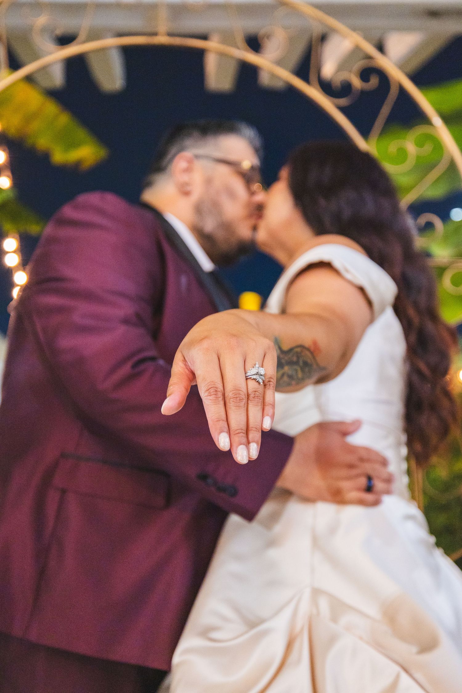 Couple sharing a romantic dance moment at an outdoor evening wedding reception with twinkle lights.
