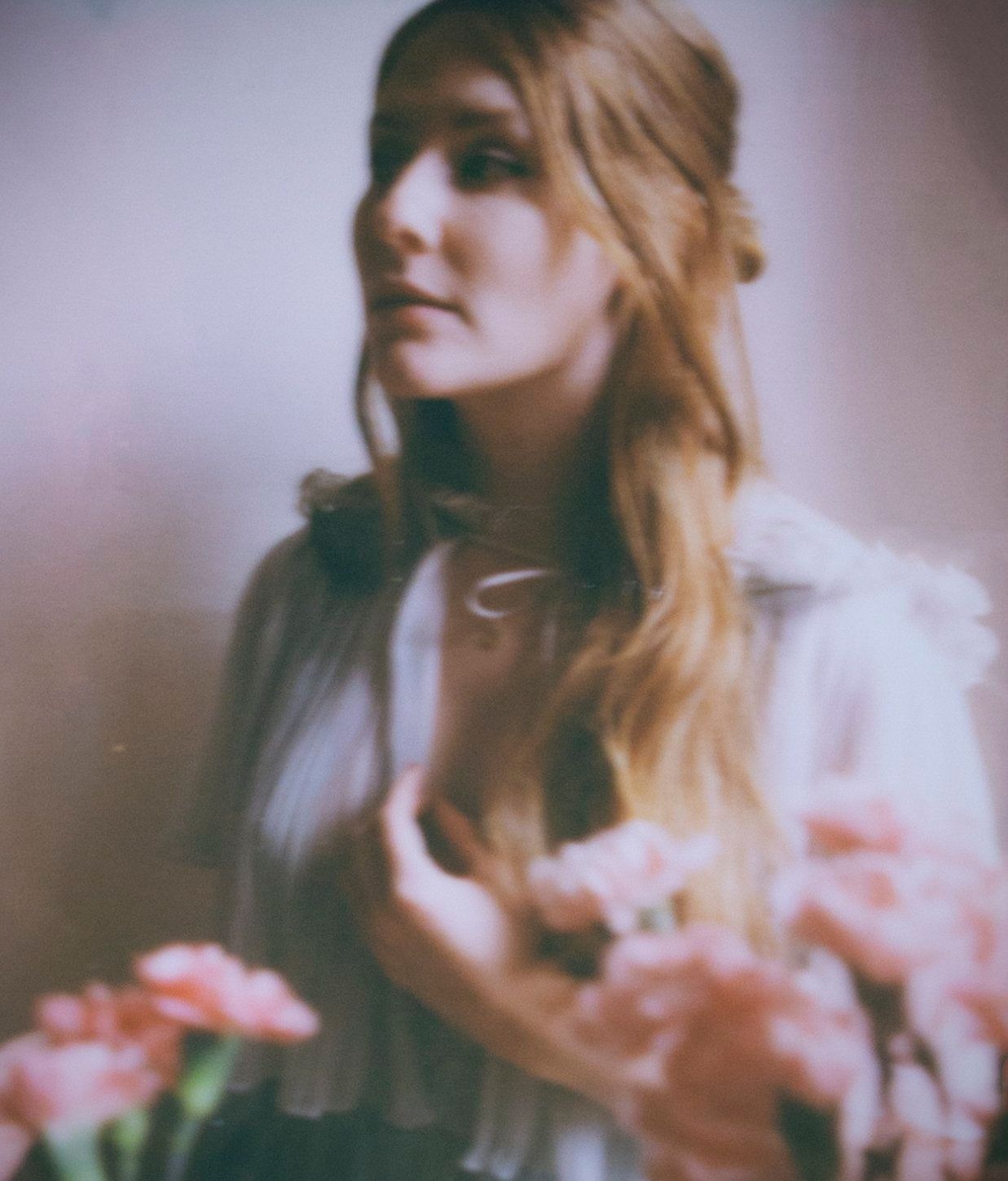 Soft focus portrait with pink tones and dreamy lighting effects.