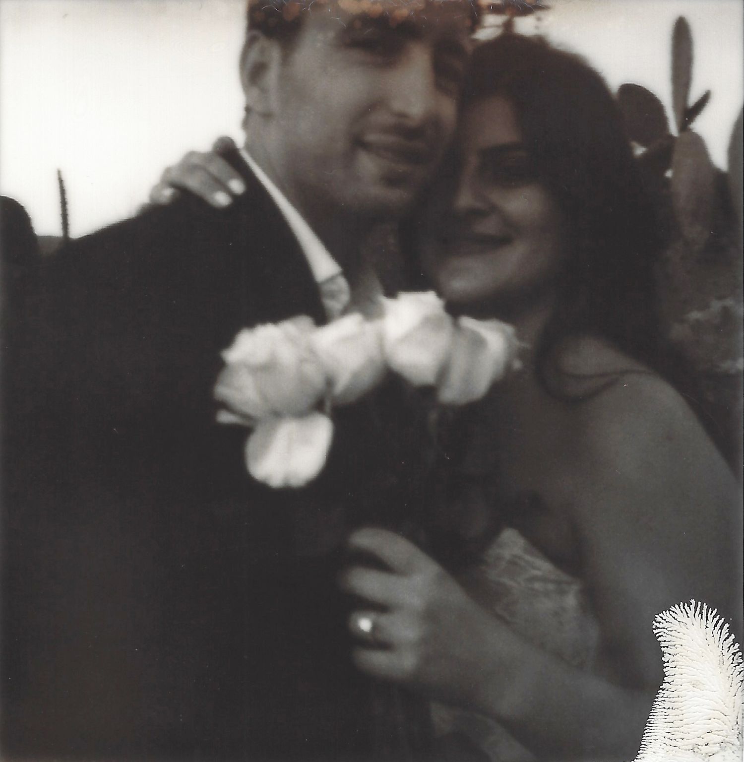 Black and white candid group moment with soft white flowers.