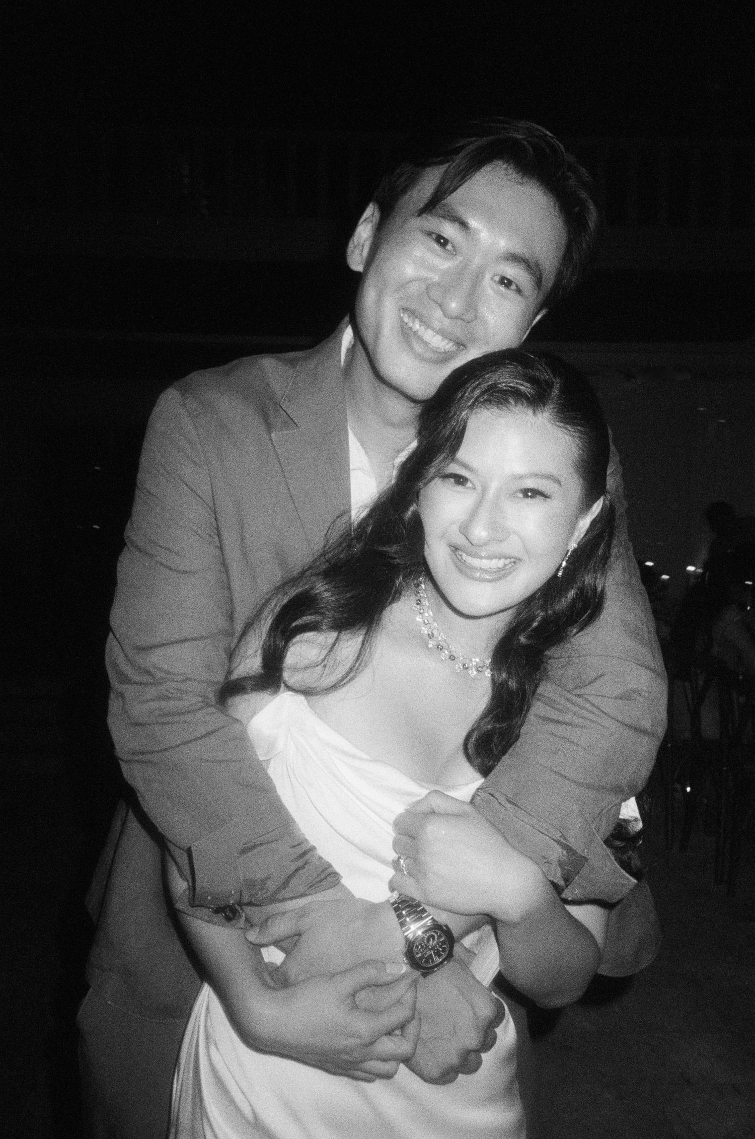 A series of black and white candid photos showing a couple embracing and posing together at a nighttime event.