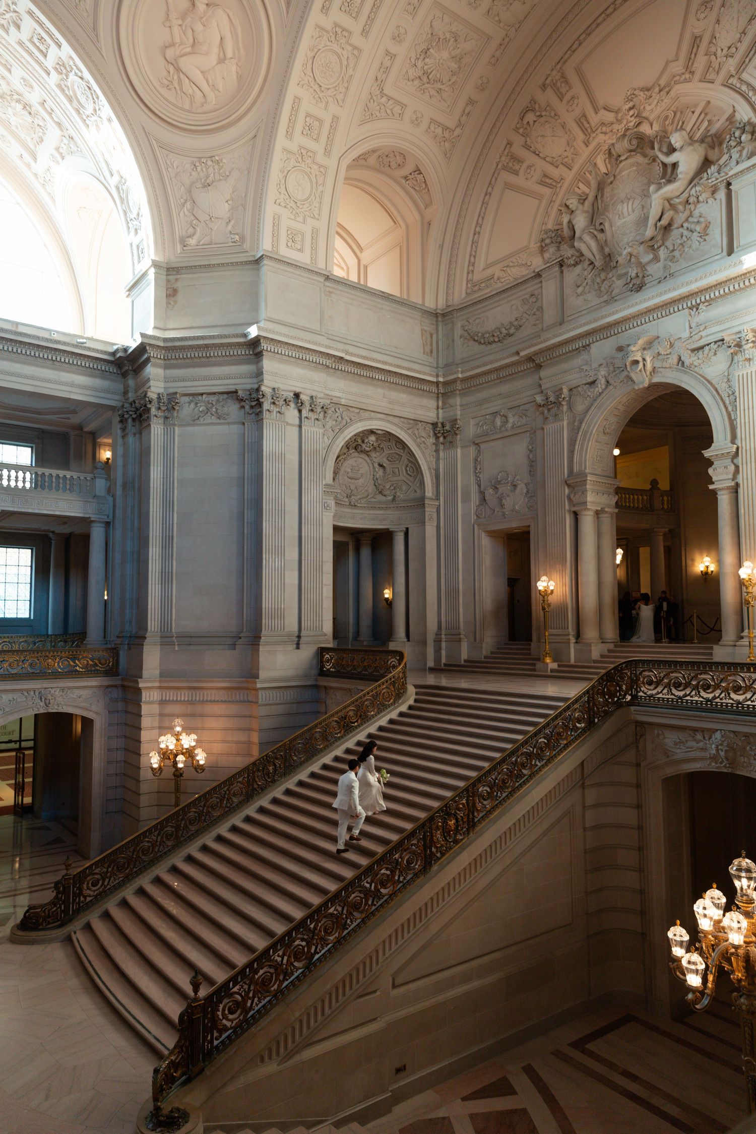 Grand interior staircase with ornate white walls, elegant marble steps, and classic architectural details.