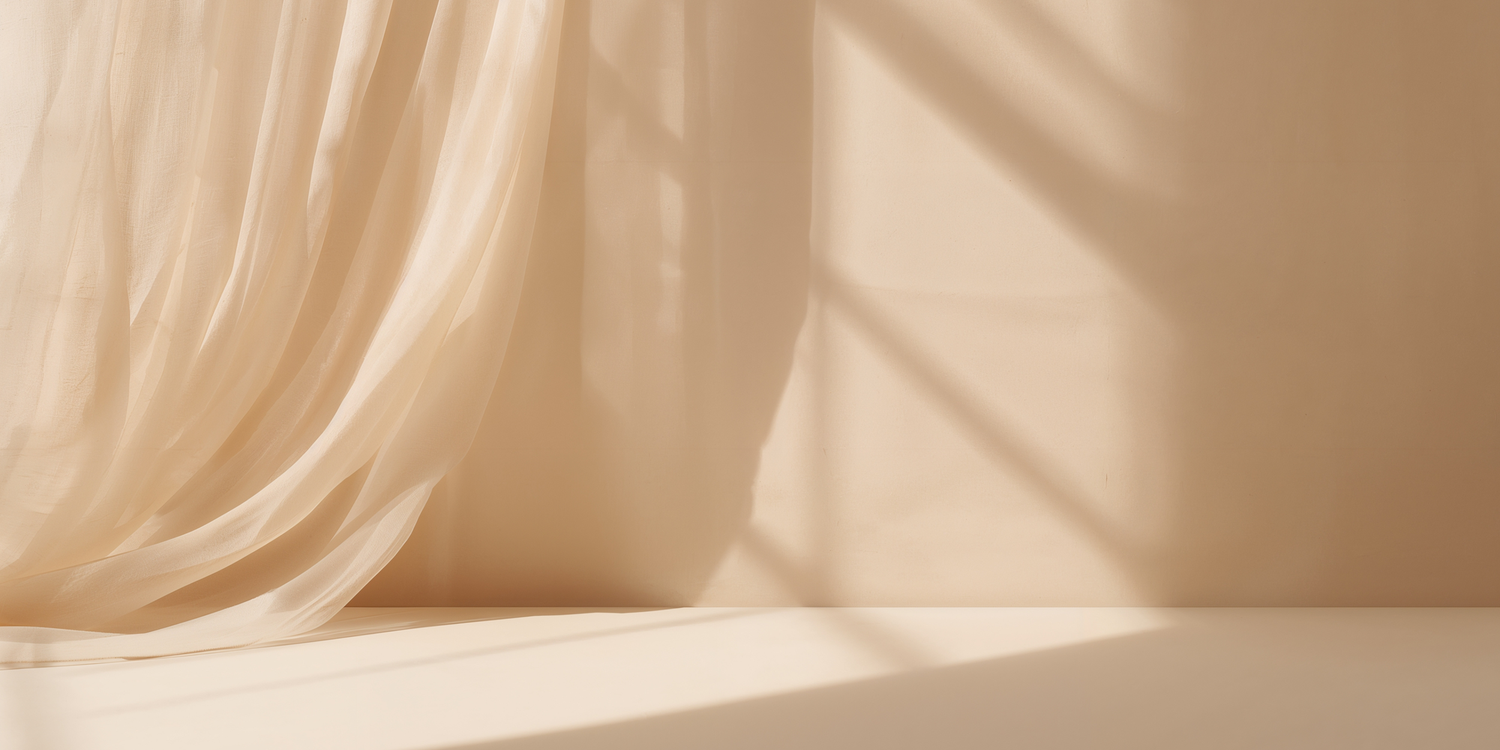 Soft beige silk fabric drapes in elegant folds creating a luxurious textural background.