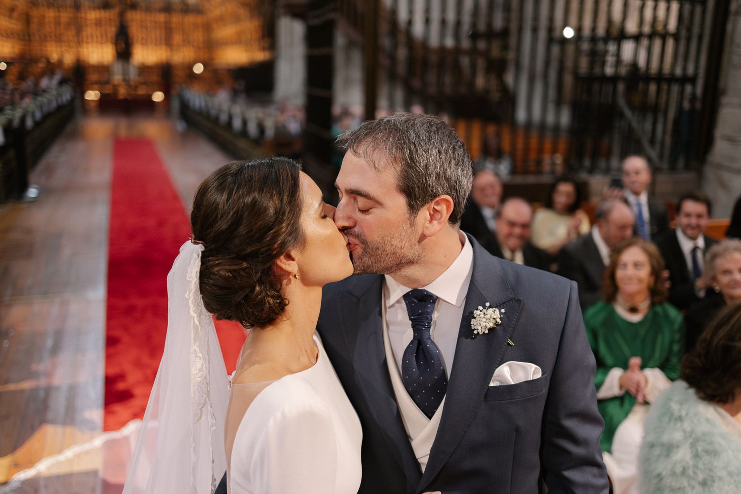 Newlywed couple sharing a first kiss at the altar during a church wedding ceremony.