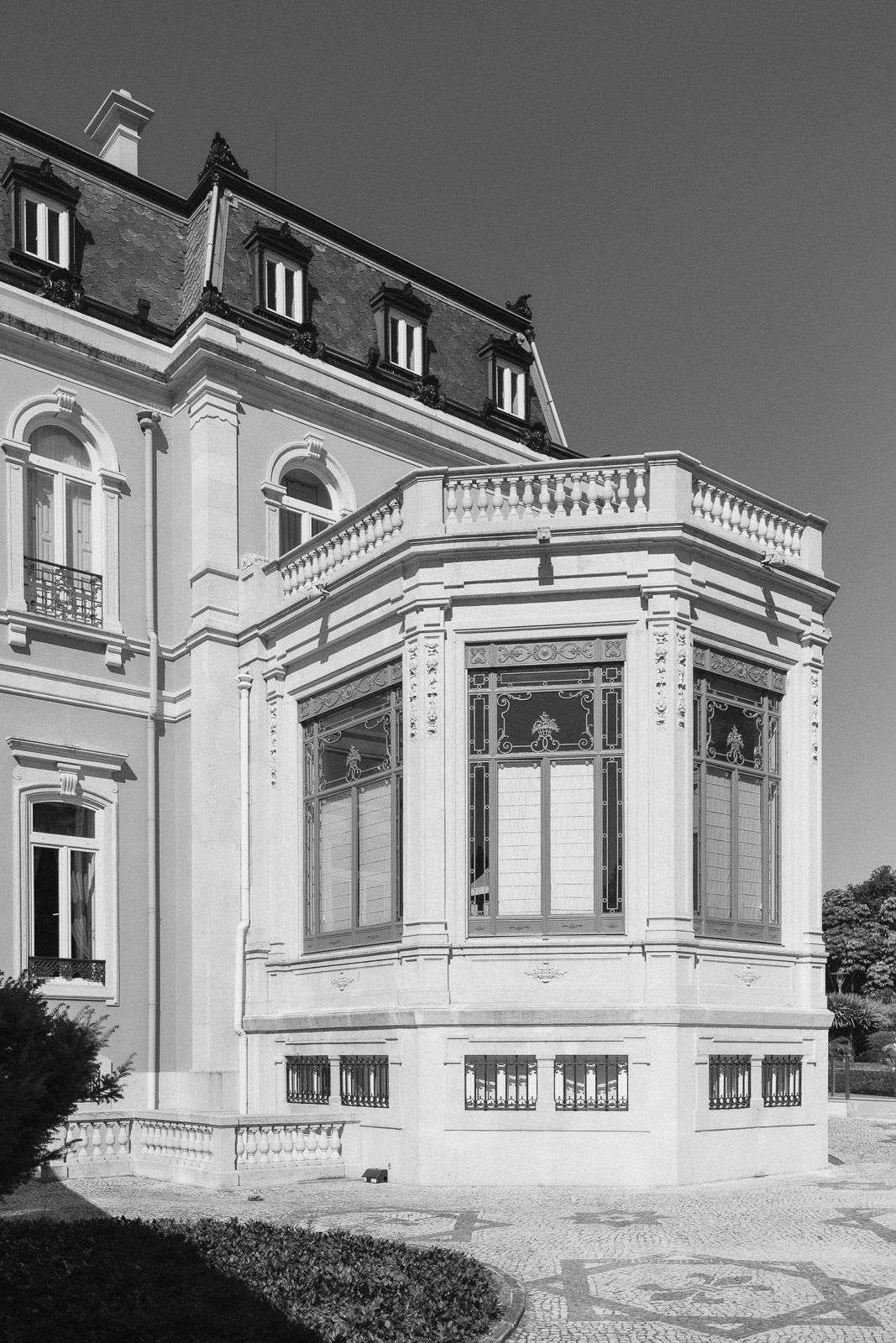 Black and white photo of an elegant historic villa with ornate bay window and classical architectural details.