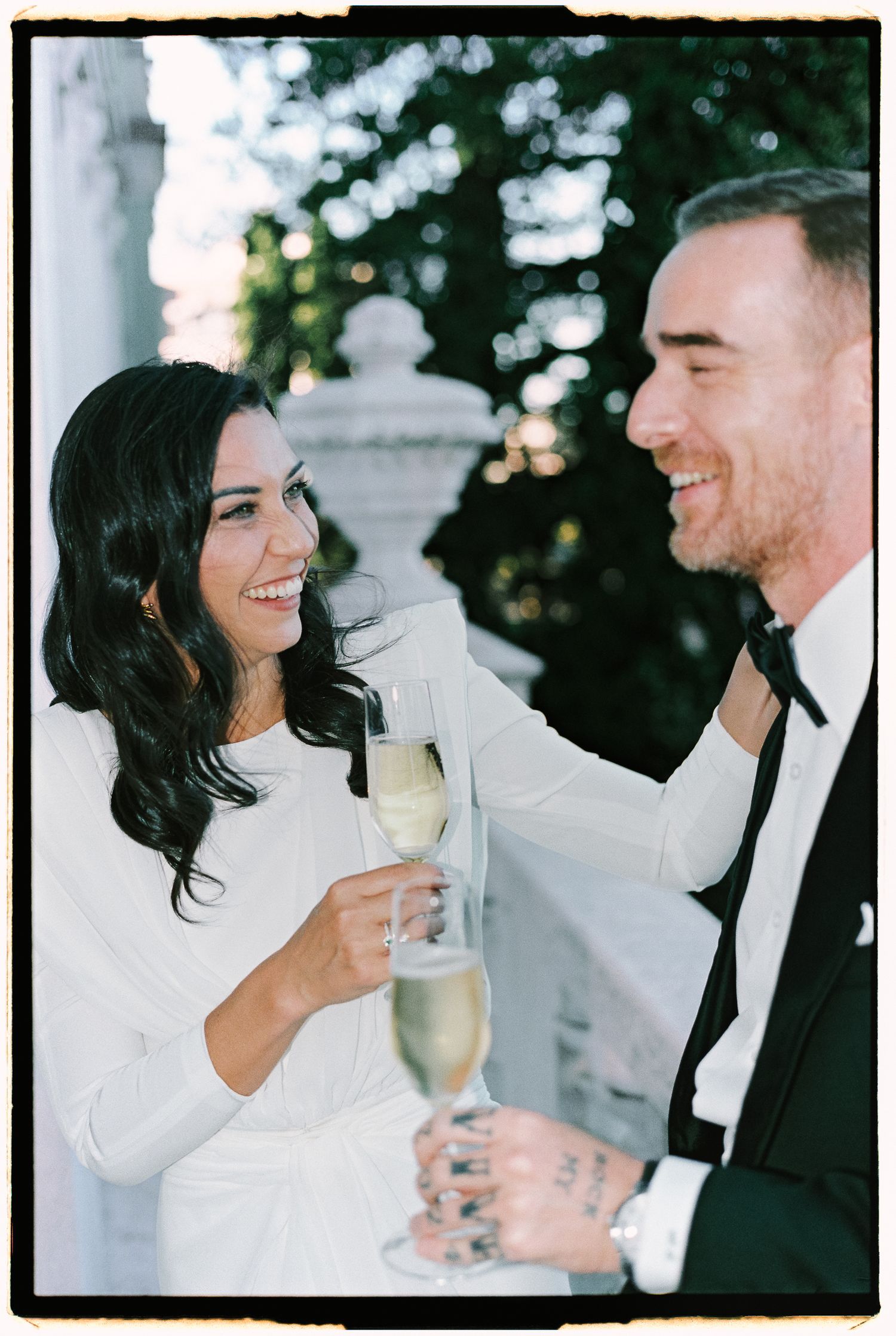 Candid black and white image series of couple sharing champagne and laughing together during a celebration.