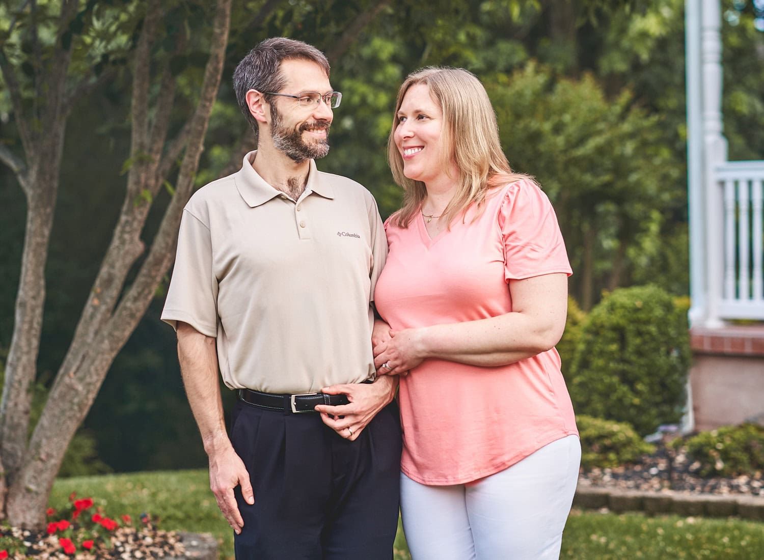 30-something couple in clasped arm embrace looking adoringly at one another