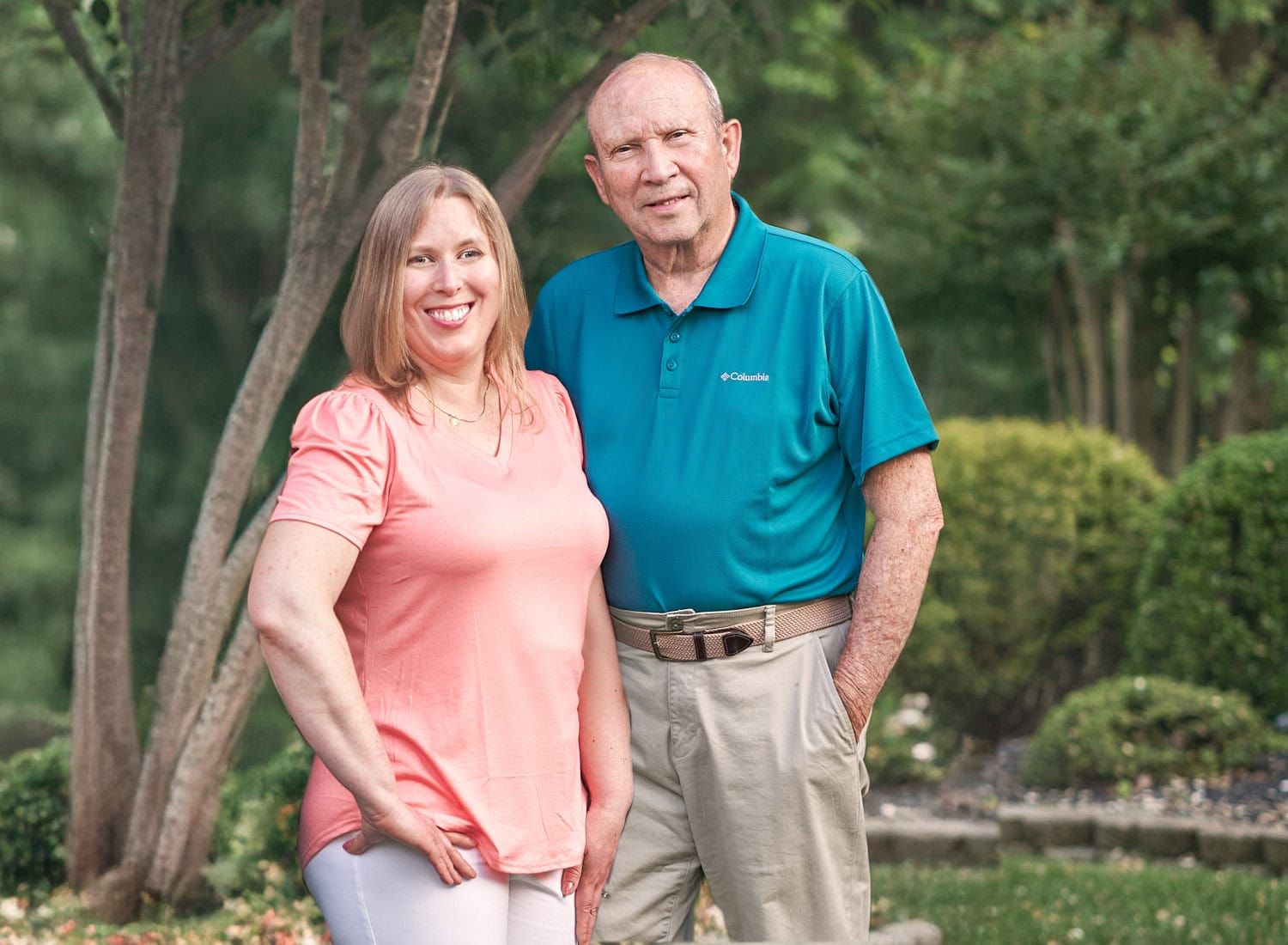 Elderly dad and adult daughter enjoying a photo moment together in their front yard