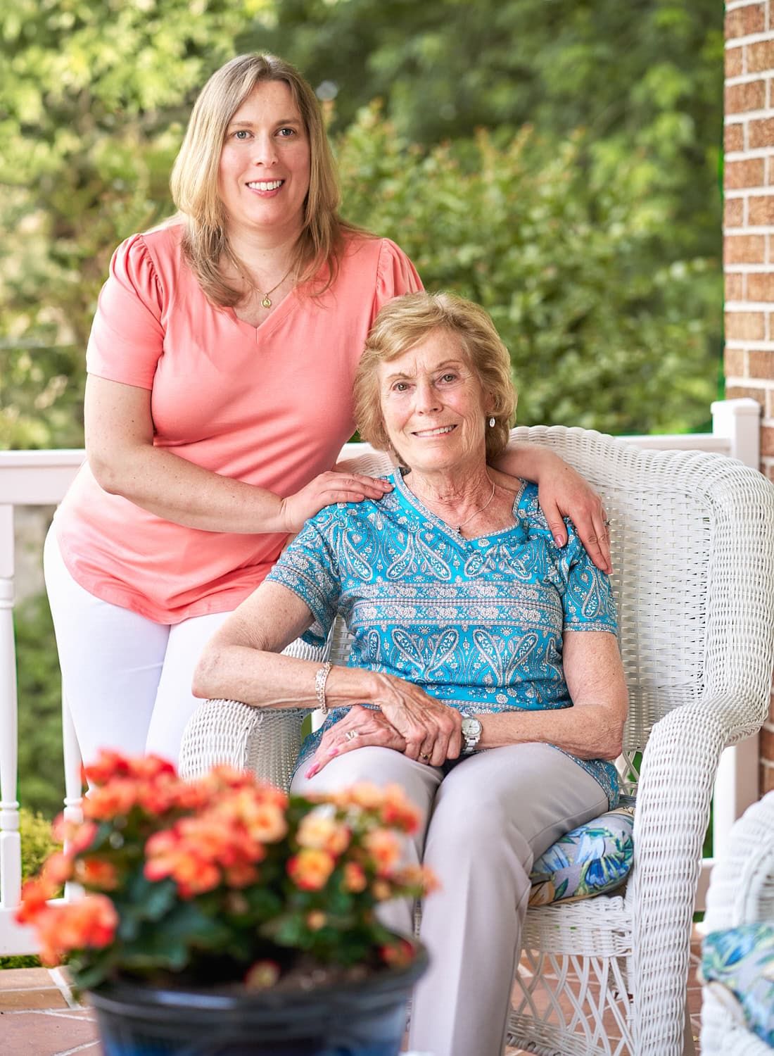 Elderly mother and 30-something daughter on wicker chair on family's Perry Hall MD porch