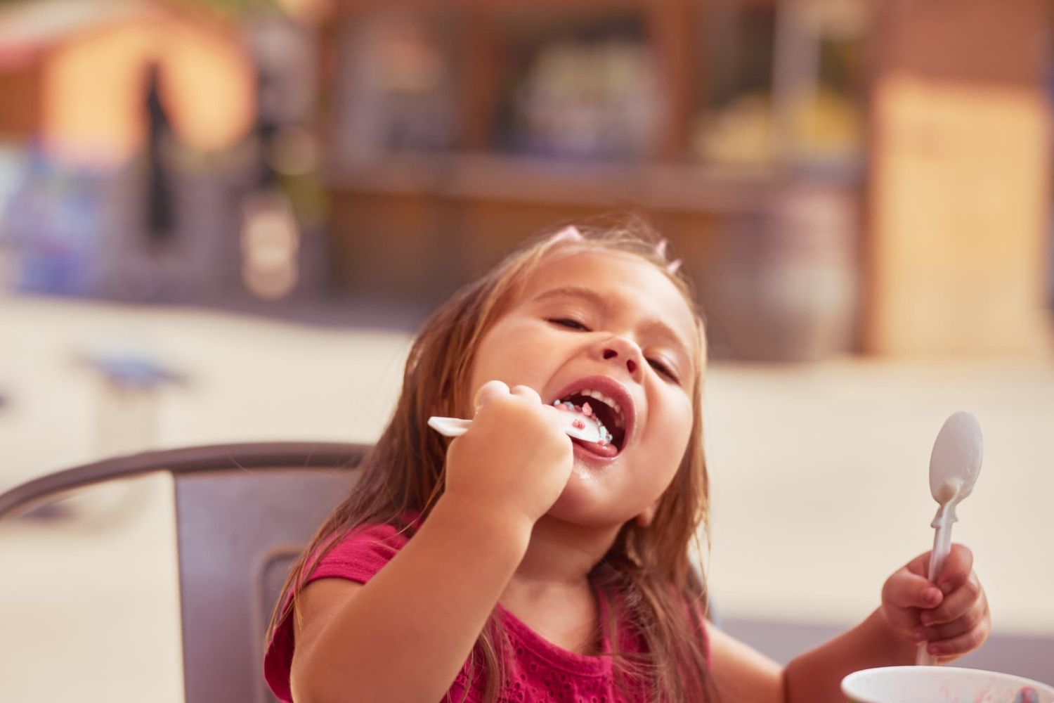 Toddler girl enjoying sprinkles from her ice cream
