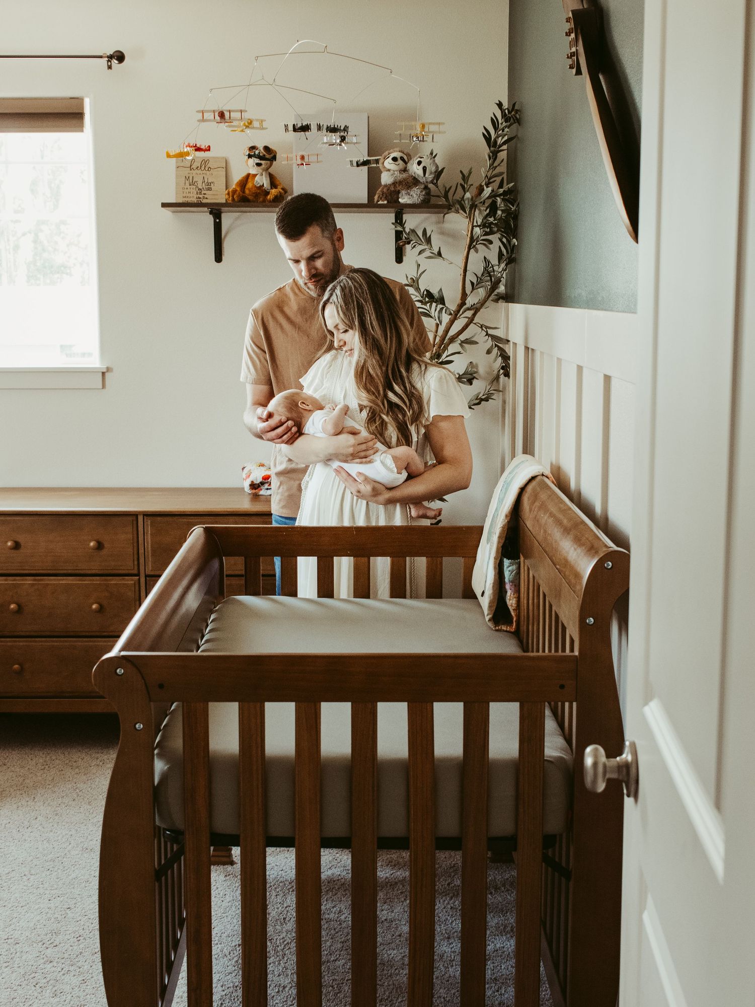 Interior nursery scene with wooden crib and decorative wall shelf.