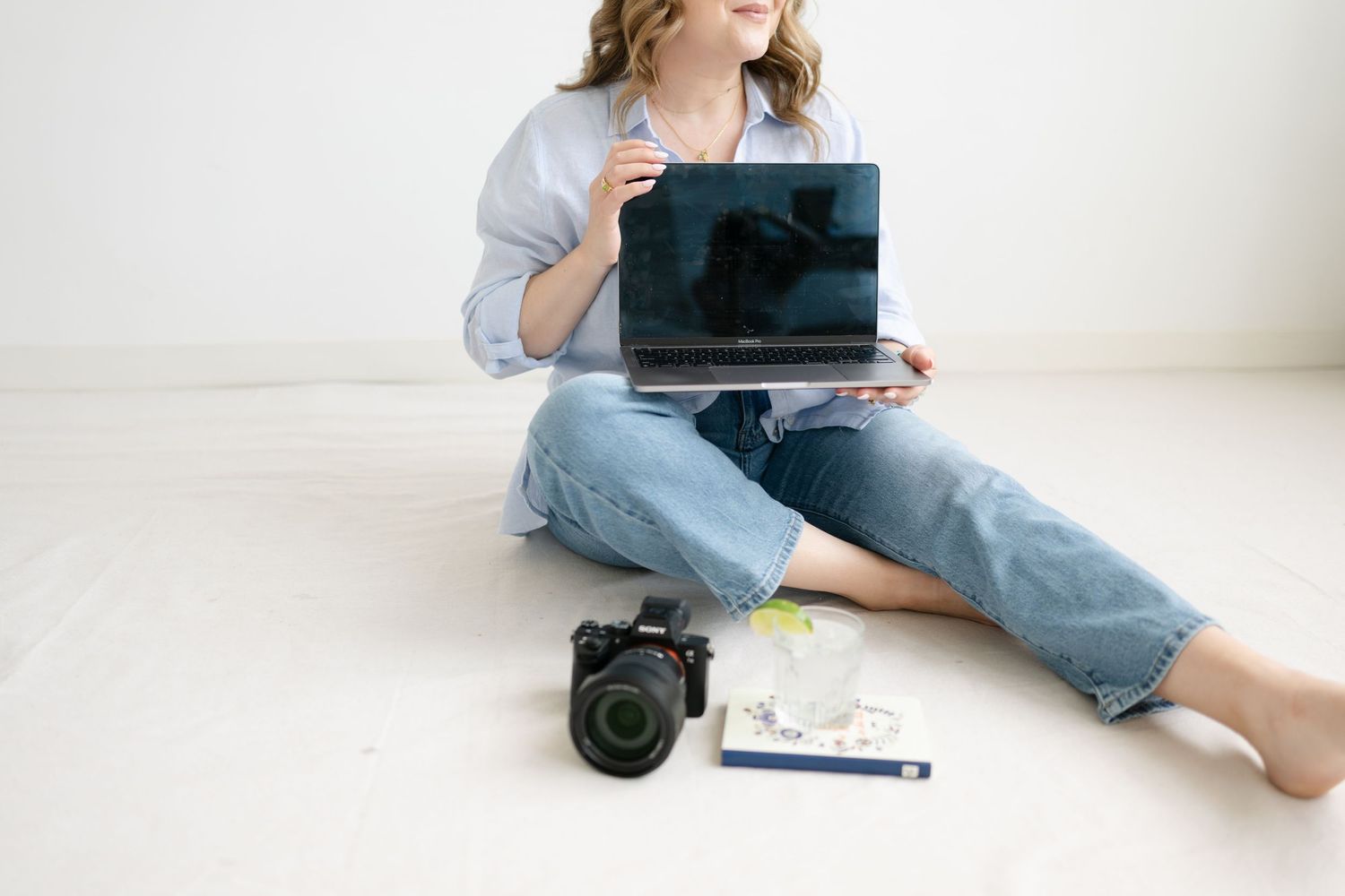 Person sitting in casual attire with blue tablet device looking at x-ray or medical scan in bright room.