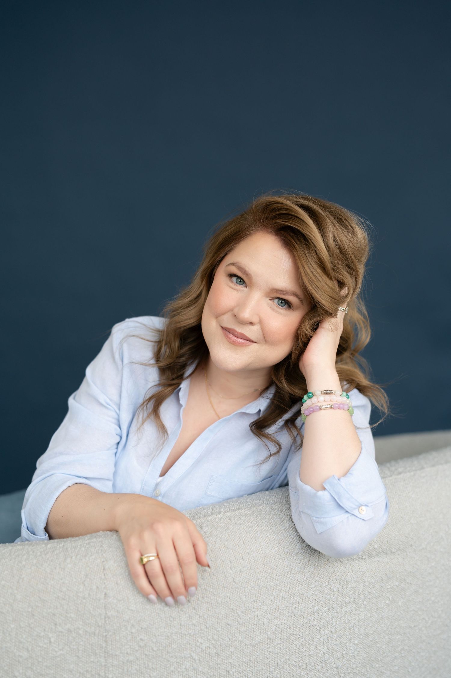 A series of professional headshots showing someone in a light blue button-down shirt against a dark backdrop.