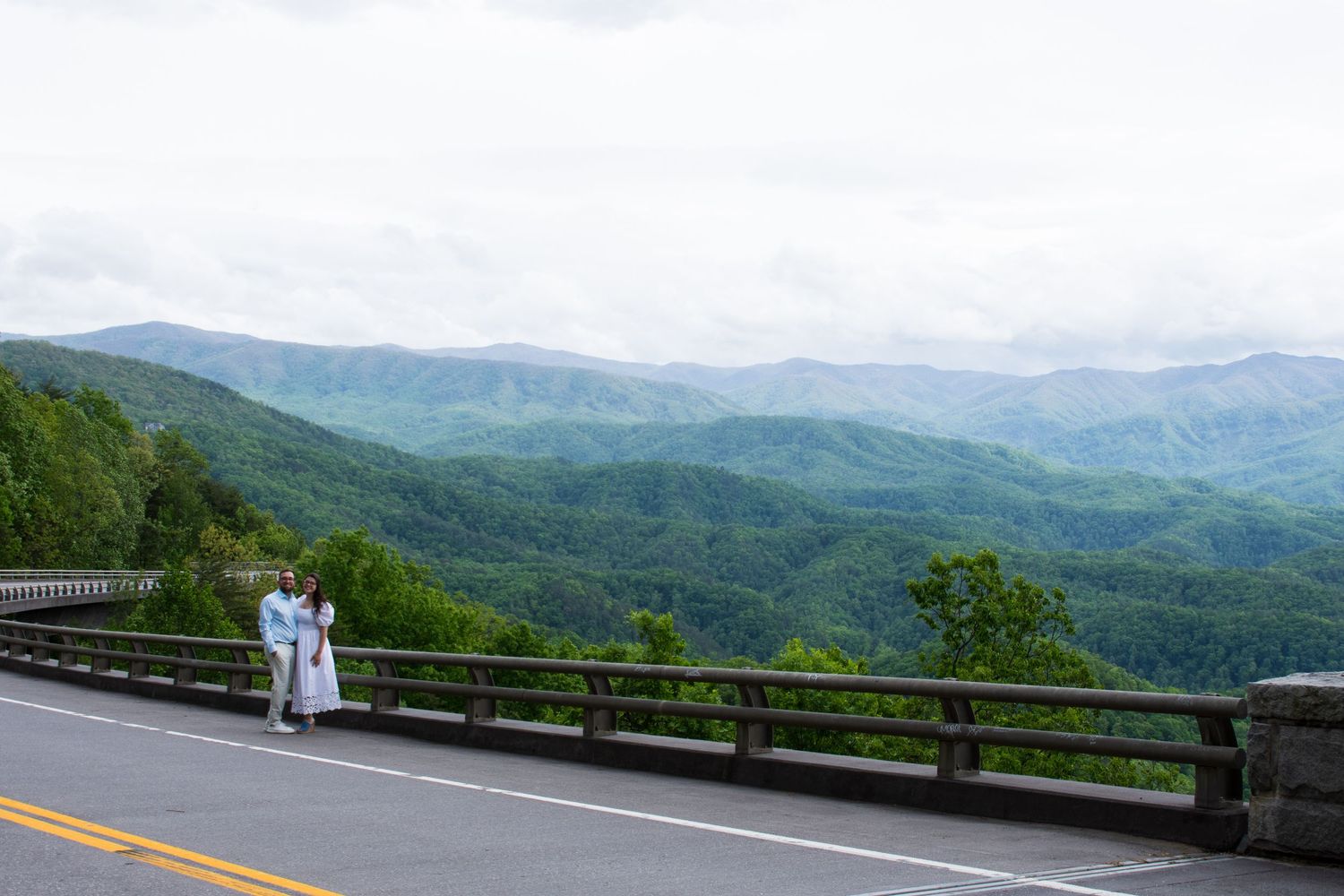 A scenic mountain road overlook with panoramic views of the Blue Ridge Mountains in the distance.