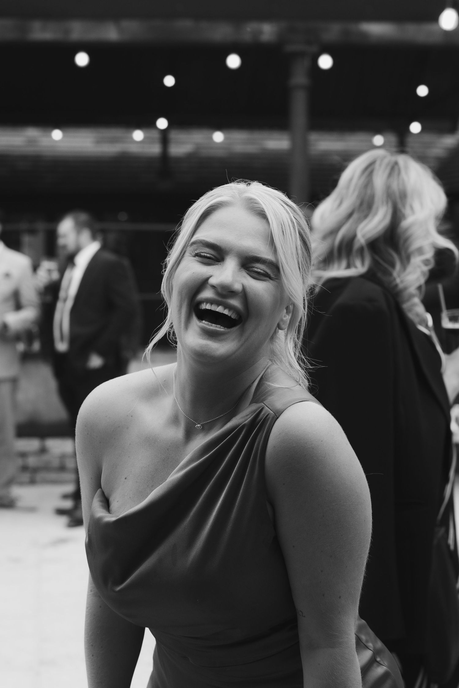 A sequence of black and white photos showing a bridesmaid laughing joyfully at a wedding at old gore barn.
