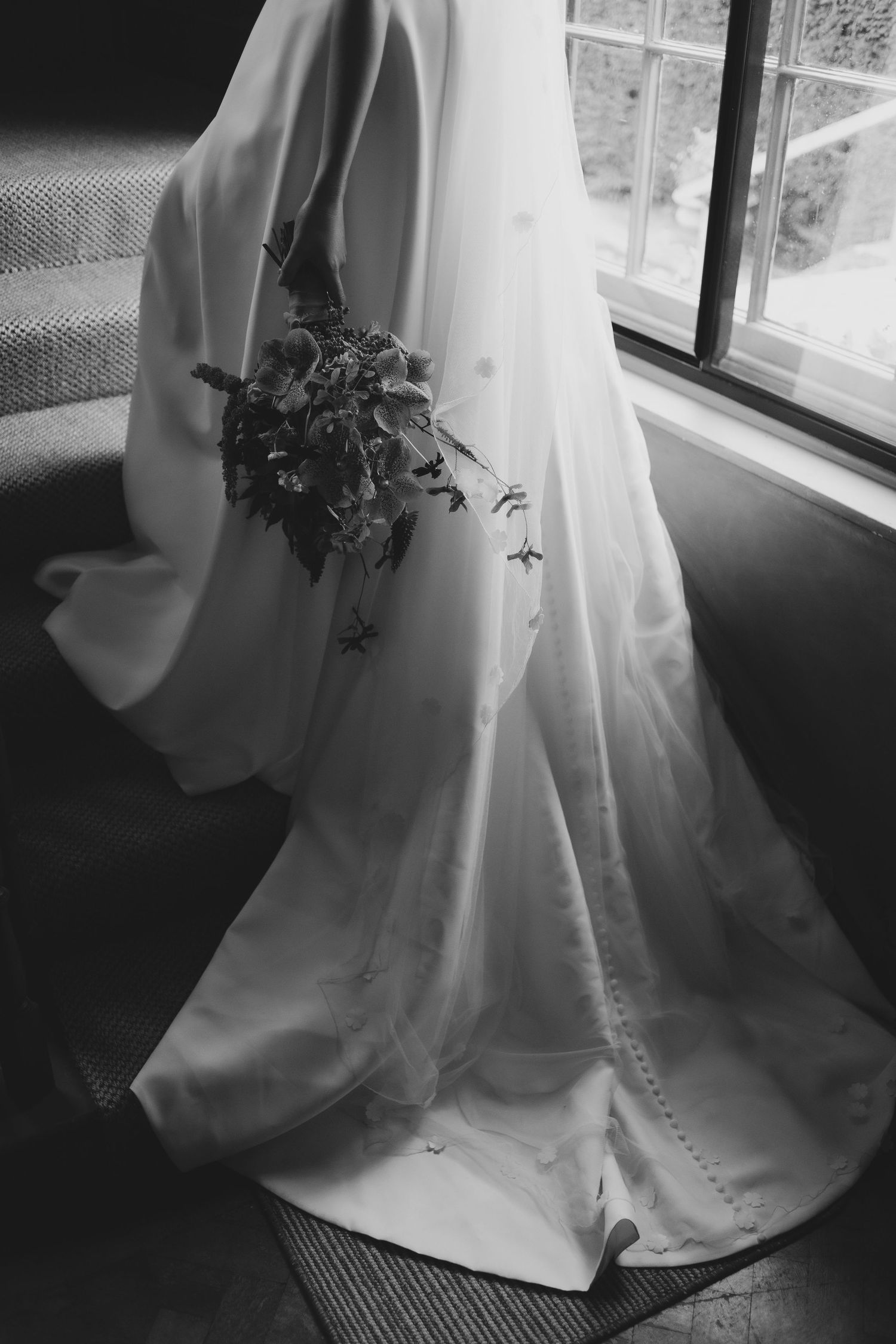 Black and white photograph of an elegant flowing wedding dress captured by cotswolds wedding photographer.