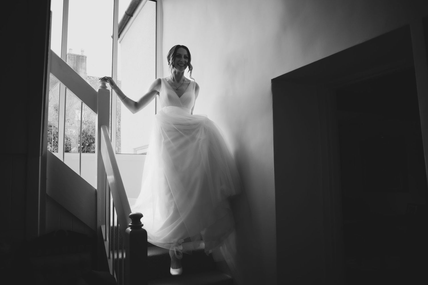 A series of black and white artistic photographs showing figures in motion against windows and natural light.