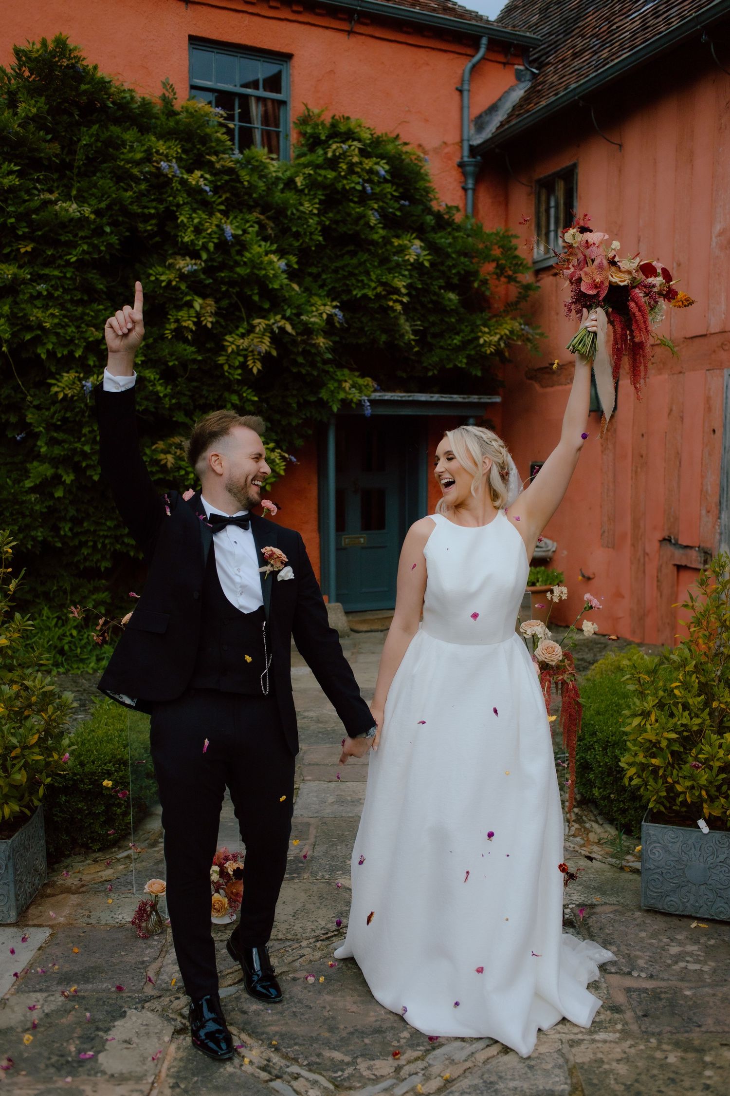 A joyful couple celebrates their wedding day in the Cotswolds at Pauntley Court wedding venue.