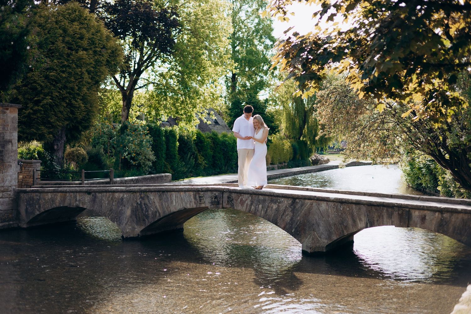 Couple celebrating their engagement in Bourton-on-the-Water.