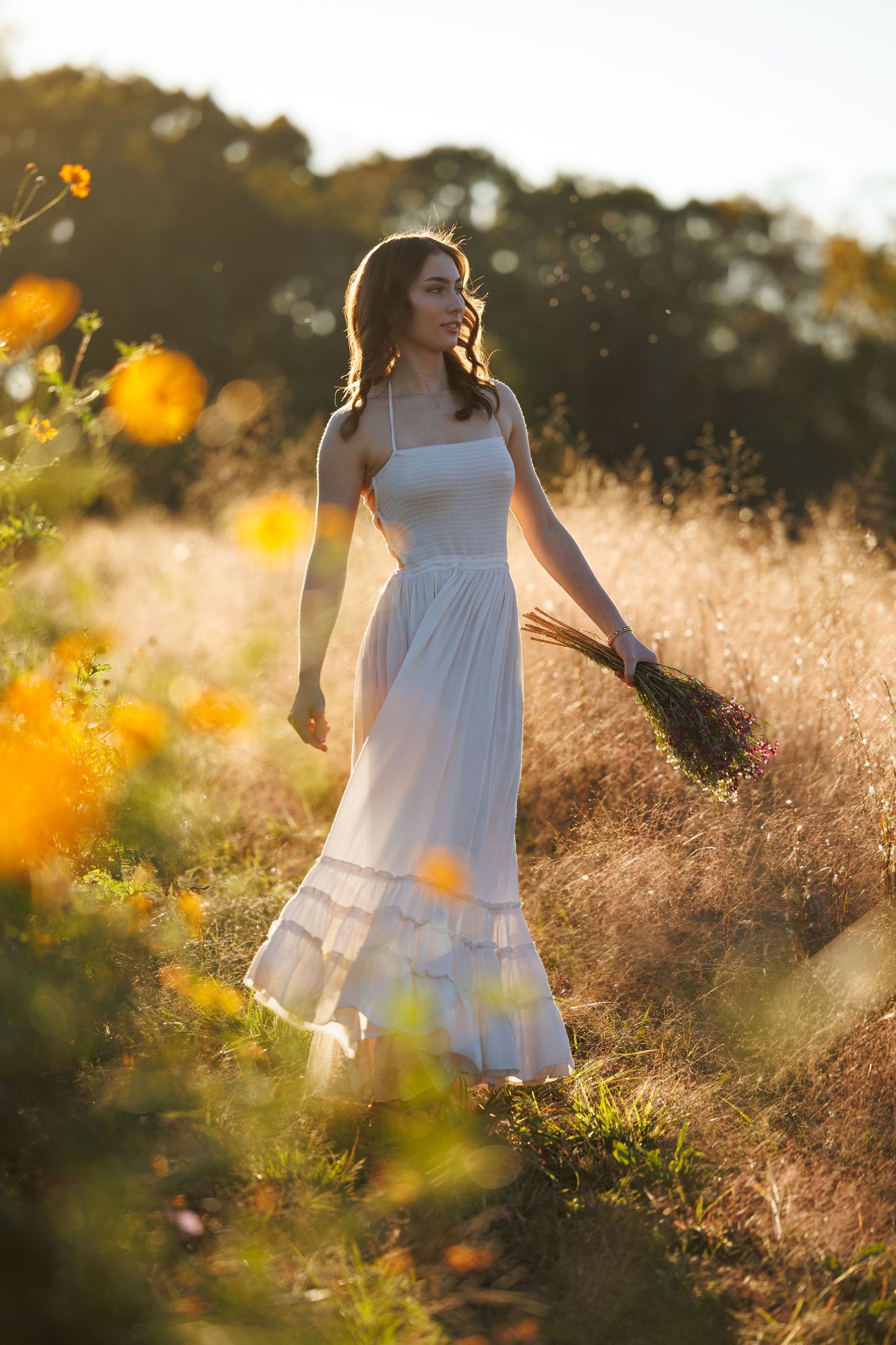 dreamy image of a girl in a field with wildflowers. senior portrait. Kernersville. dogwood farms portraits