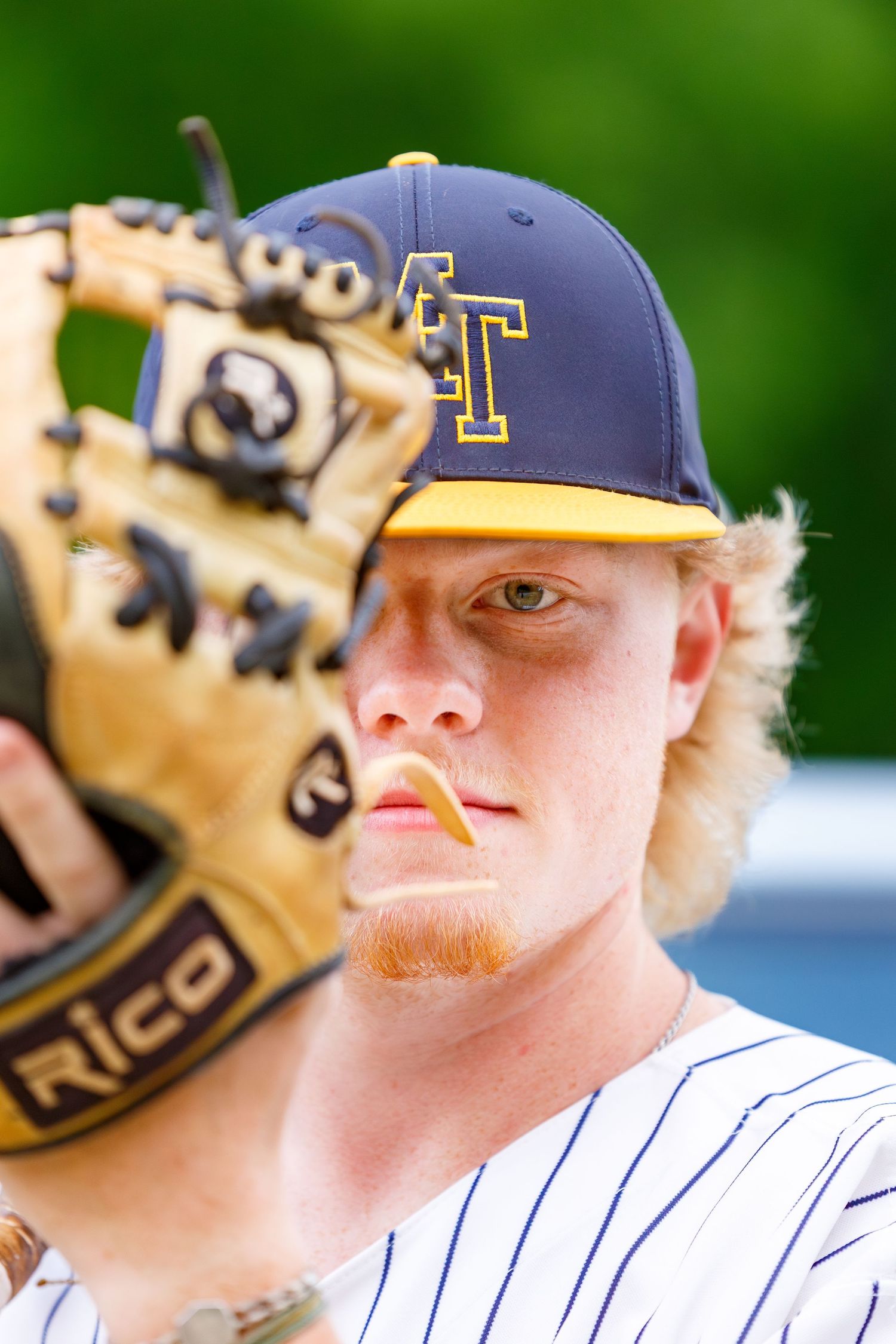 Baseball player wearing team cap and holding glove in close-up portrait.