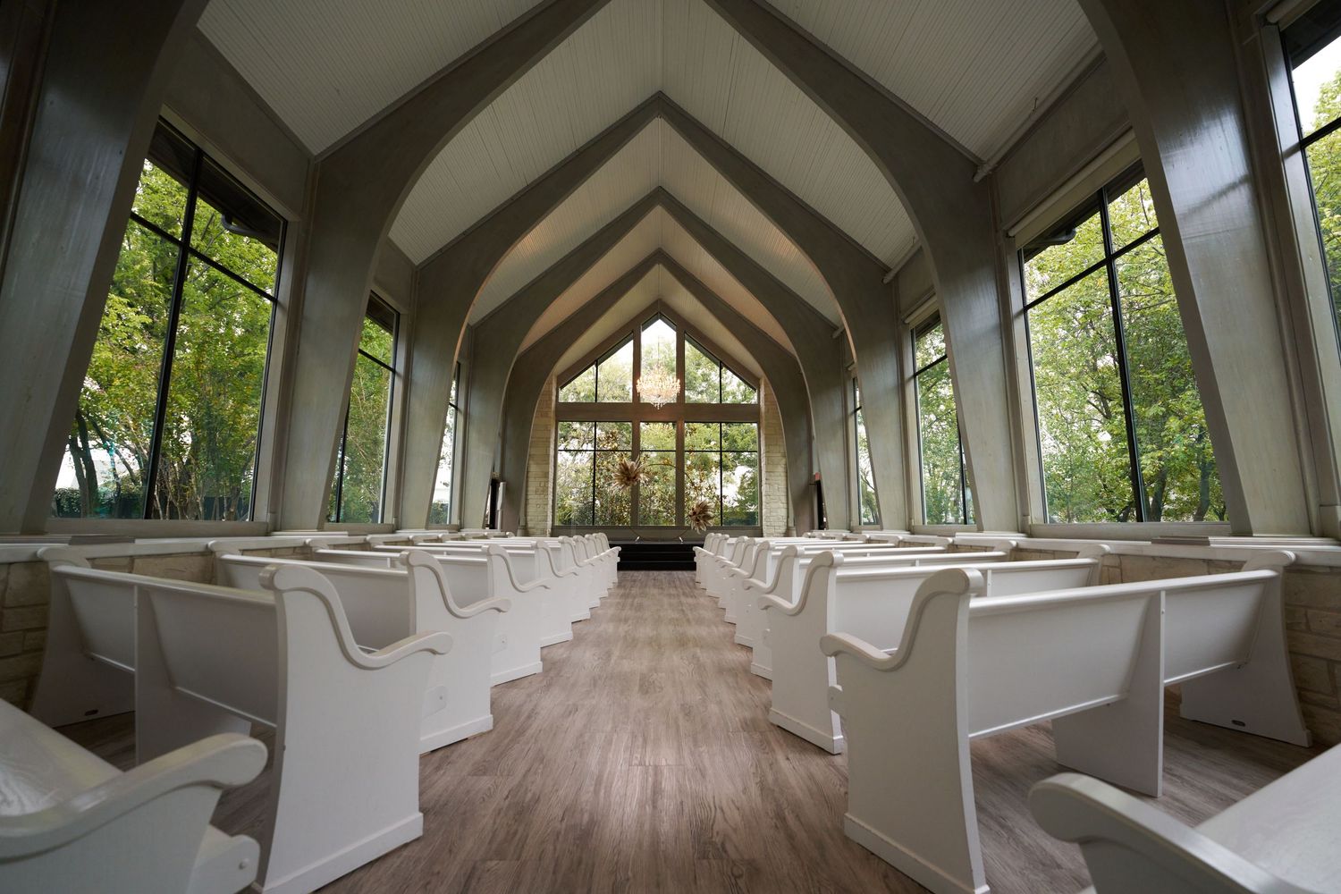 An elegant chapel interior with vaulted ceilings and large windows showcases natural lighting.