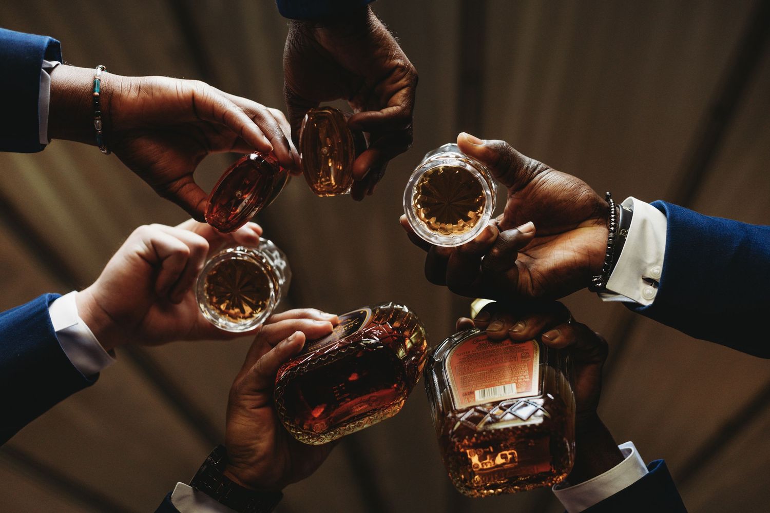 People toasting with glasses in a dimly lit setting creating a celebratory atmosphere.