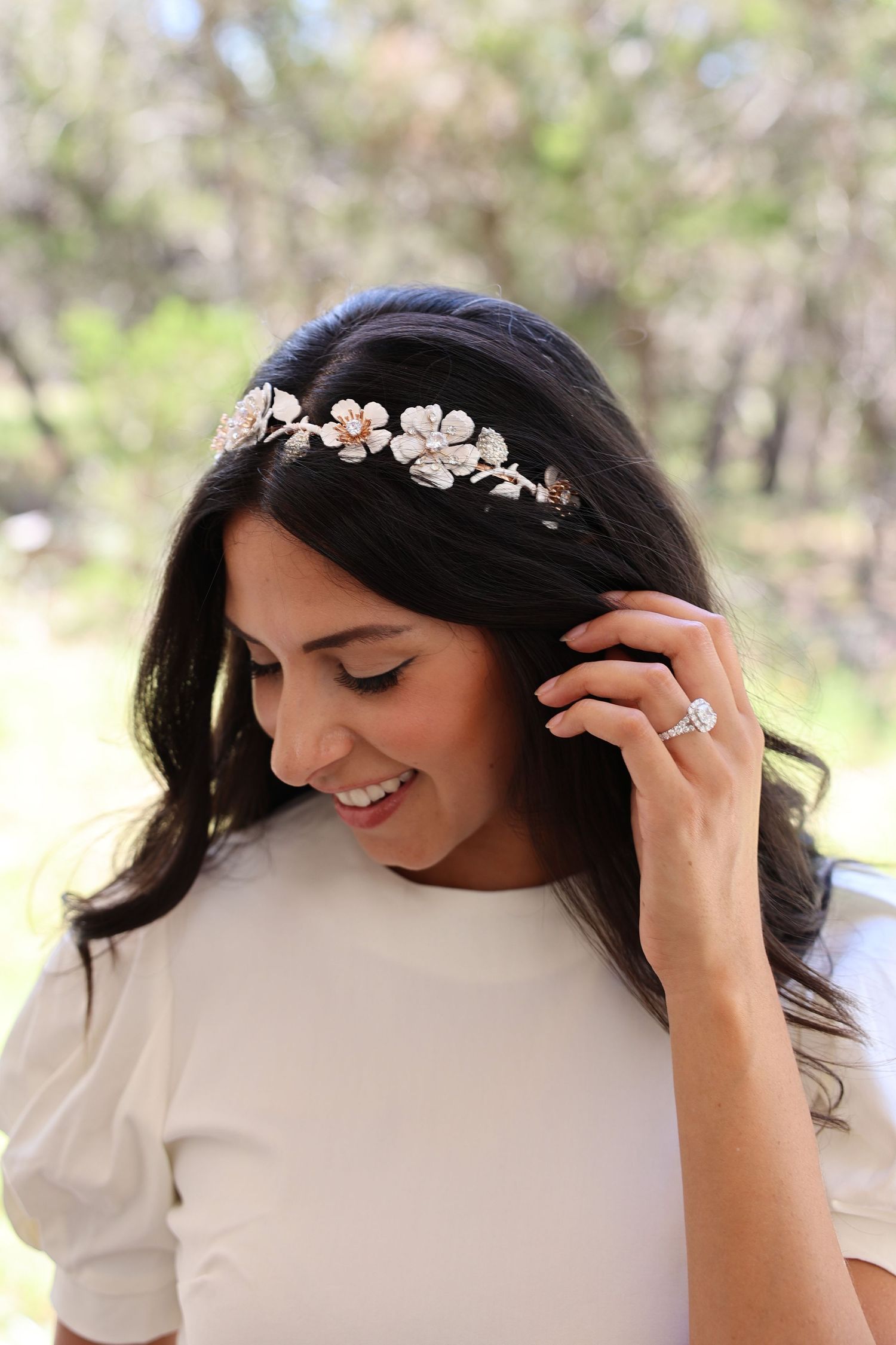Delicate floral headpiece with silver and pearl details displayed on dark hair.