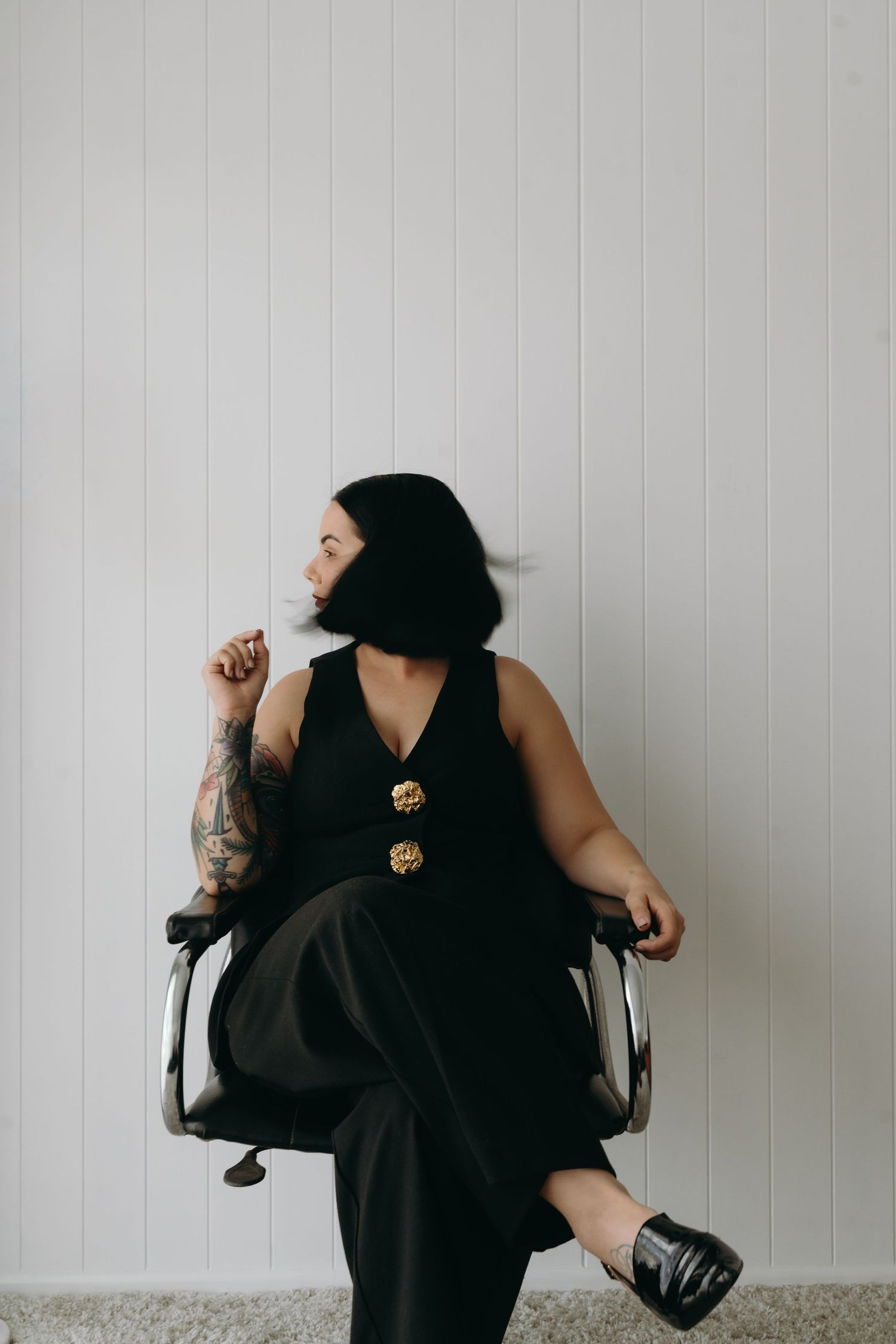 Person in black clothing strikes dynamic poses against white wall in artistic photo series.