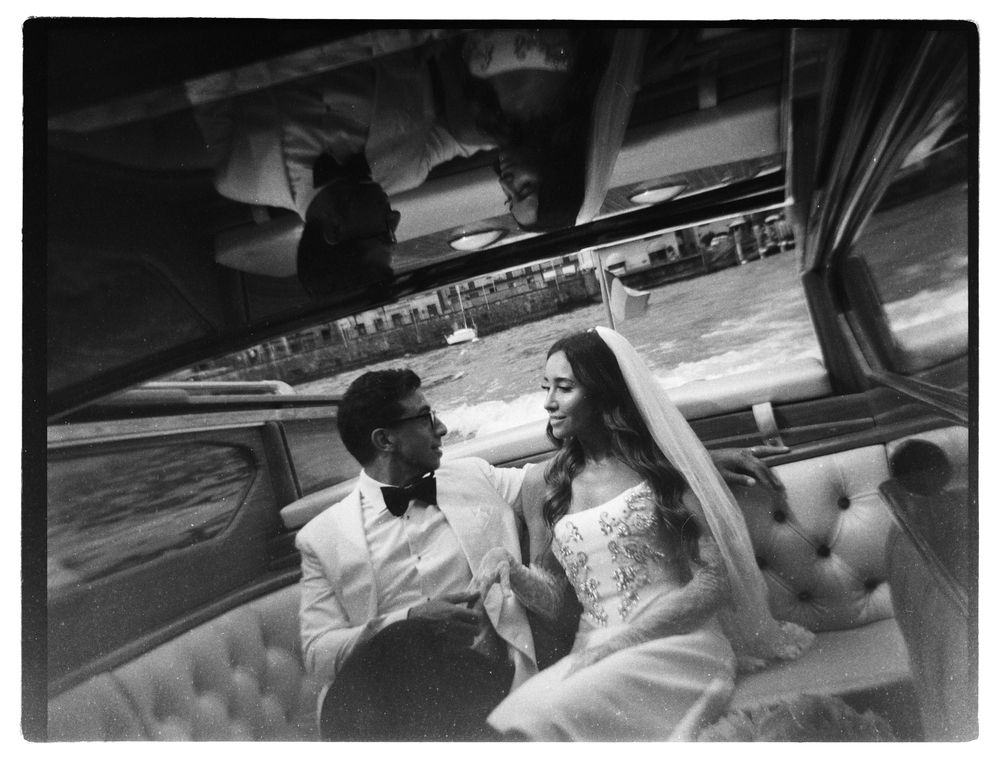 Luxury Lake Como wedding photographer website homepage featuring an elegant bride and groom on a classic wooden boat, romantic black and whi