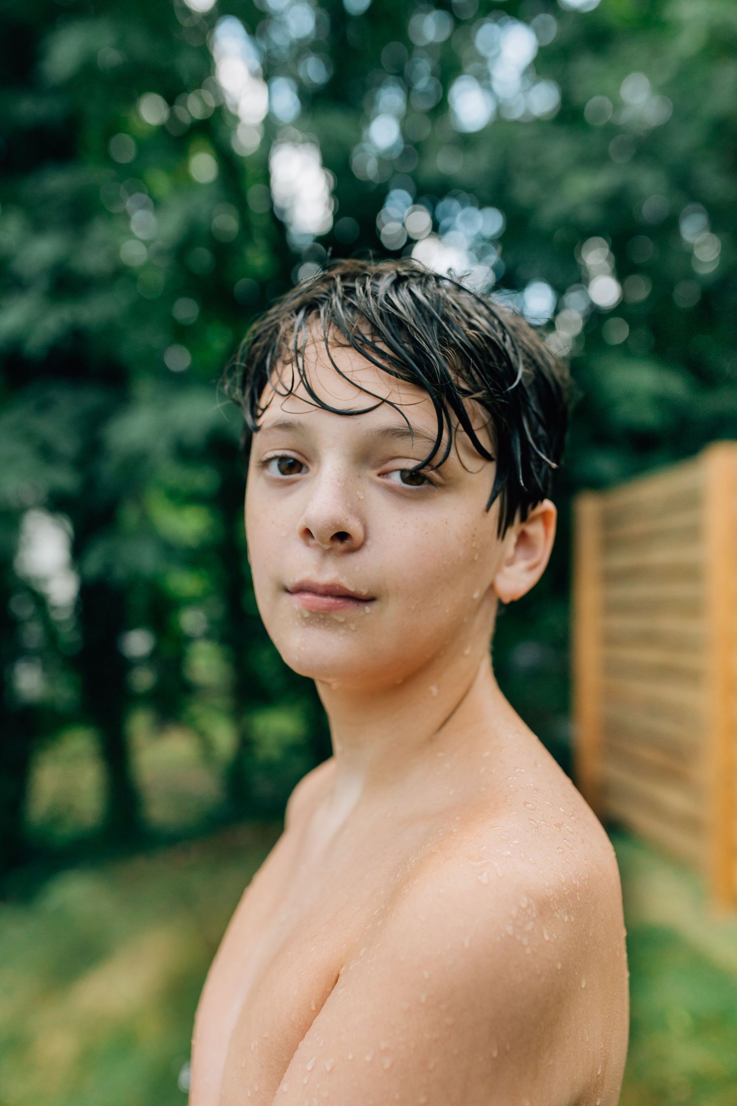 Summer portrait with wet hair and playful expression in outdoor setting.