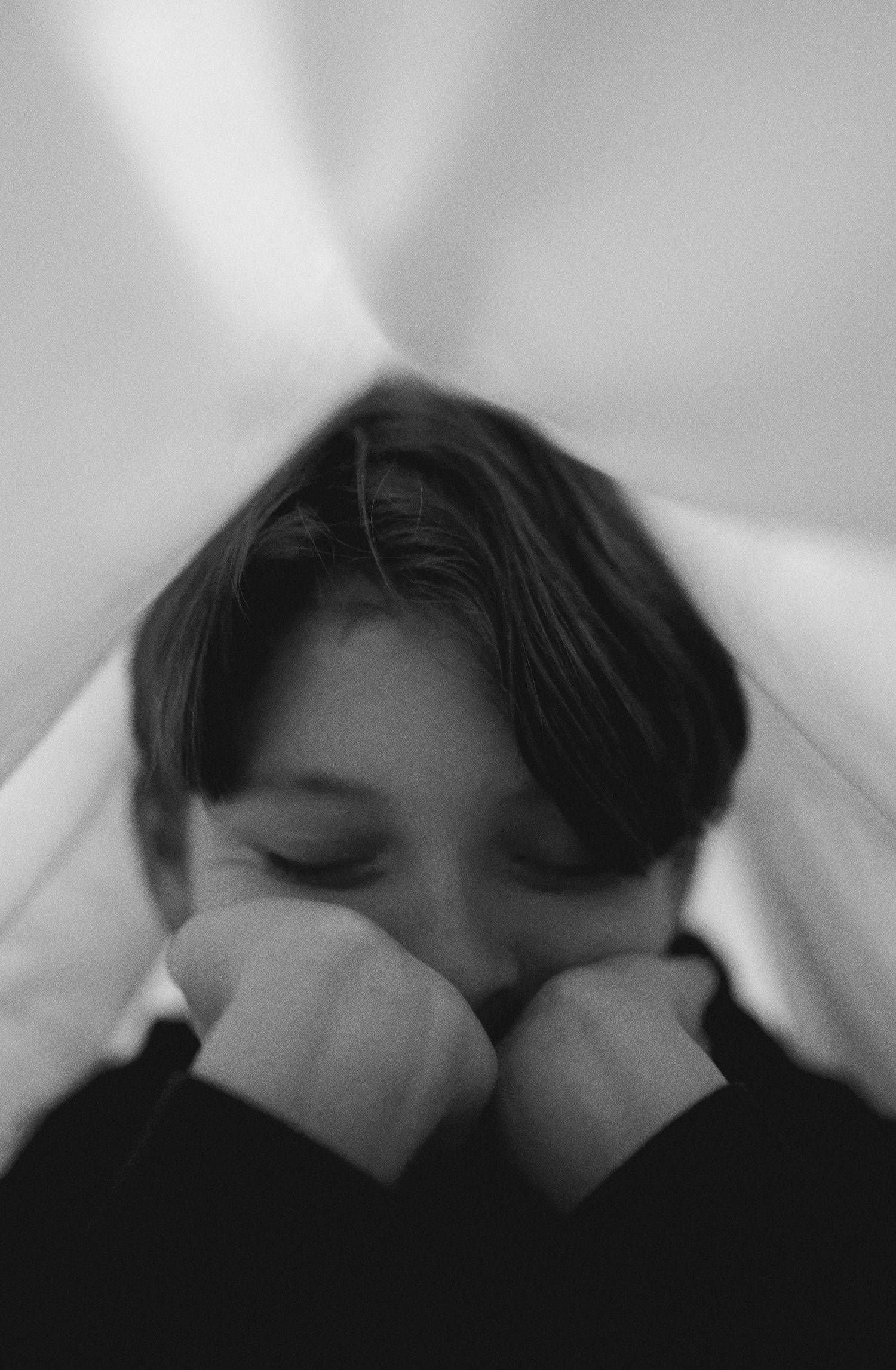 Black and white photo sequence capturing pensive moments under soft lighting.