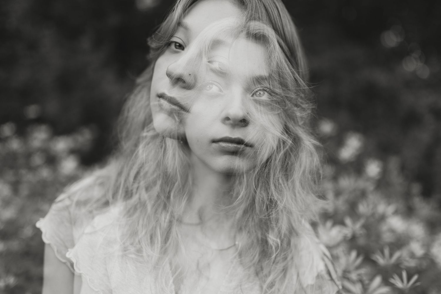Dreamy black and white portrait surrounded by delicate white flowers.