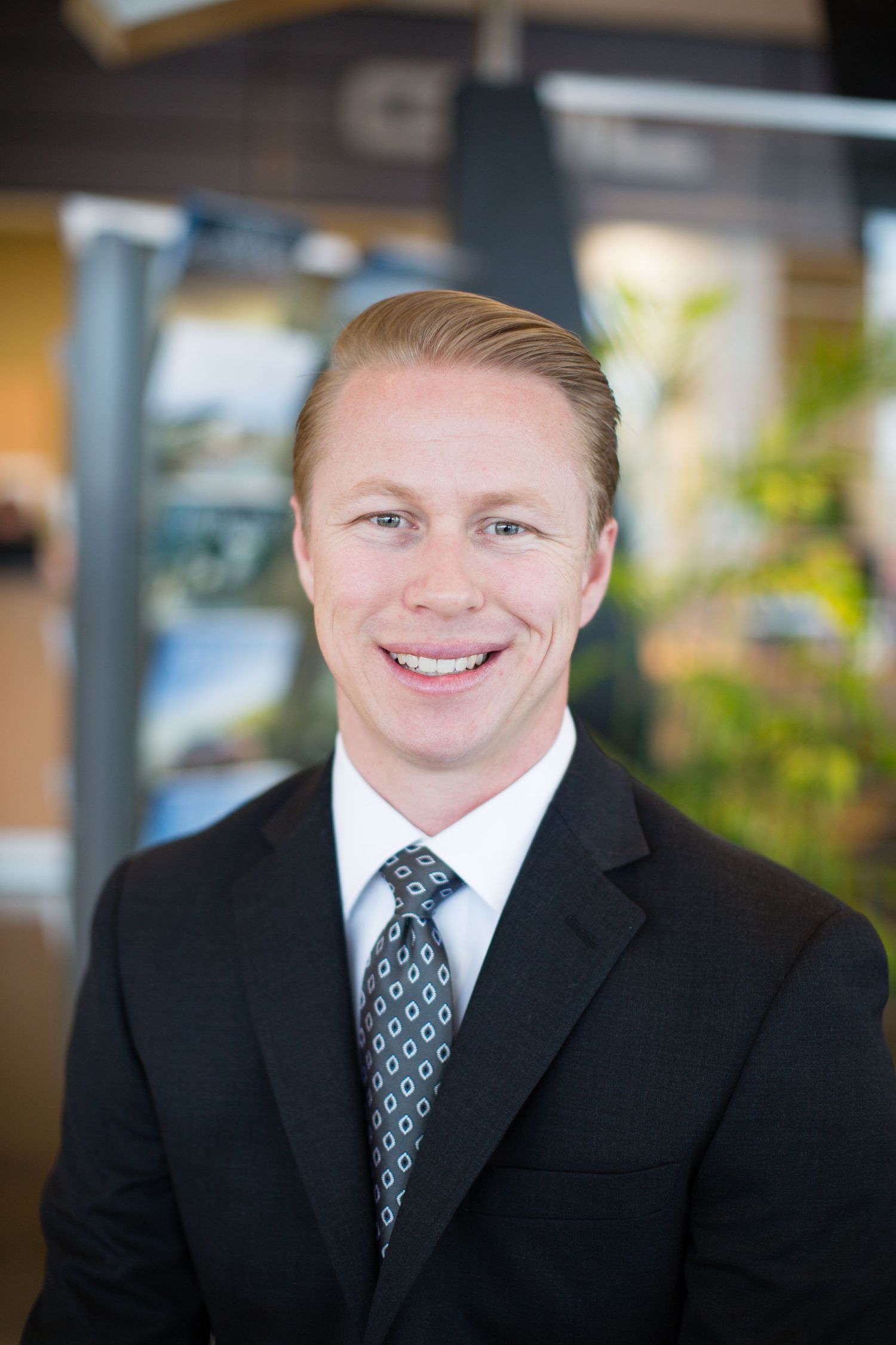 Professional wearing a black suit and polka dot tie in an office setting.