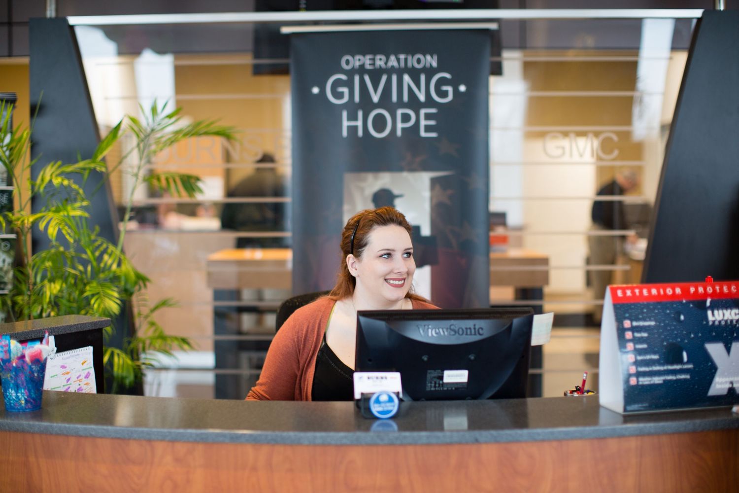 Professional office interior with modern workstations, plants and signage showing 'Giving Hope'.
