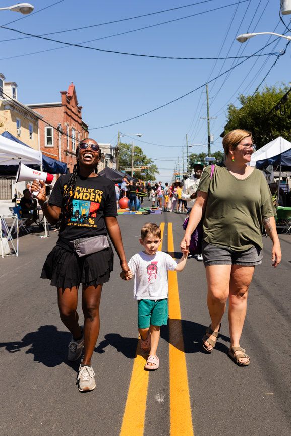Group walking down a street with yellow lines during an outdoor community event.