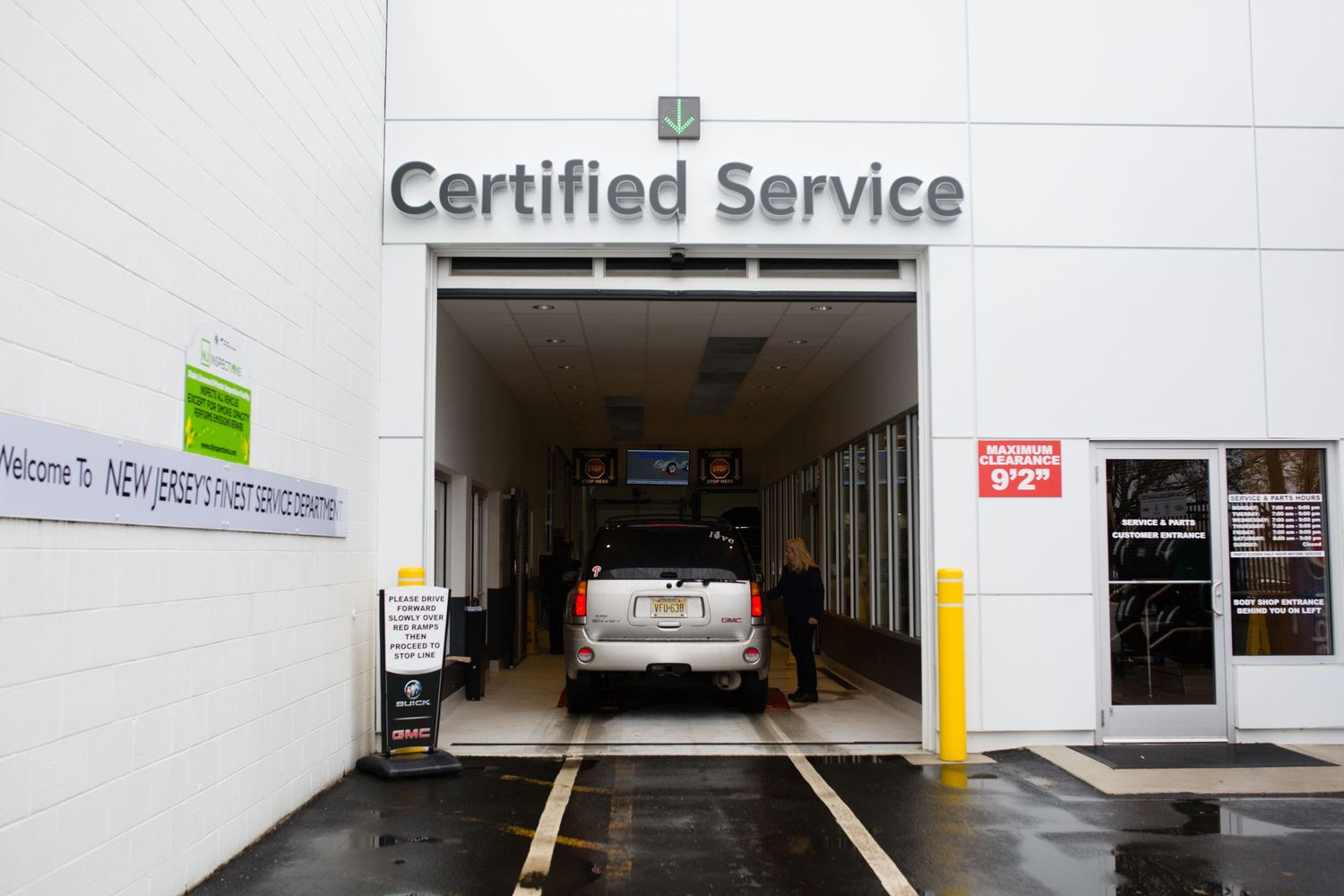 Exterior view of a certified service center entrance with parking spaces.