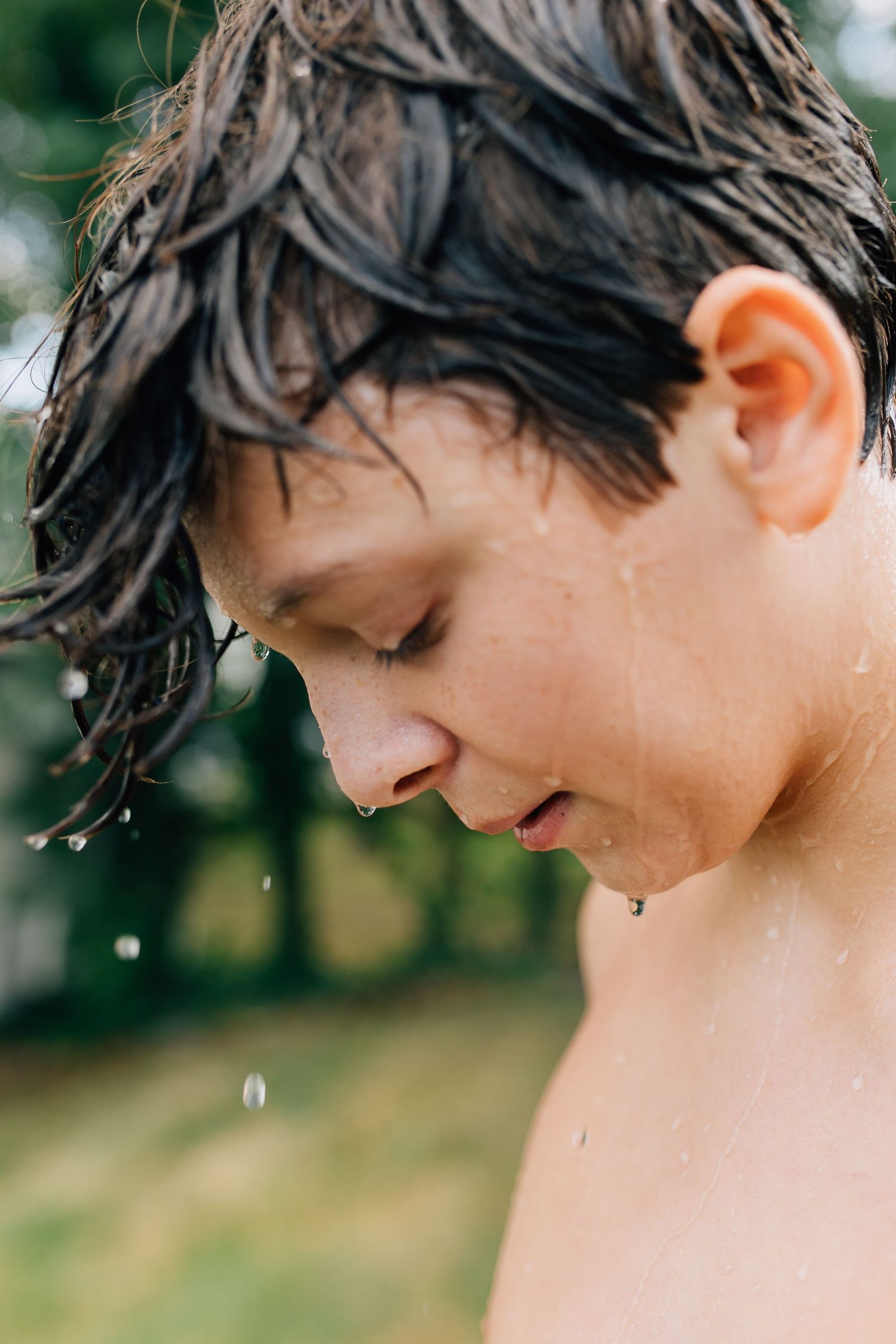 Side profile showing wet hair and water droplets during summer play.