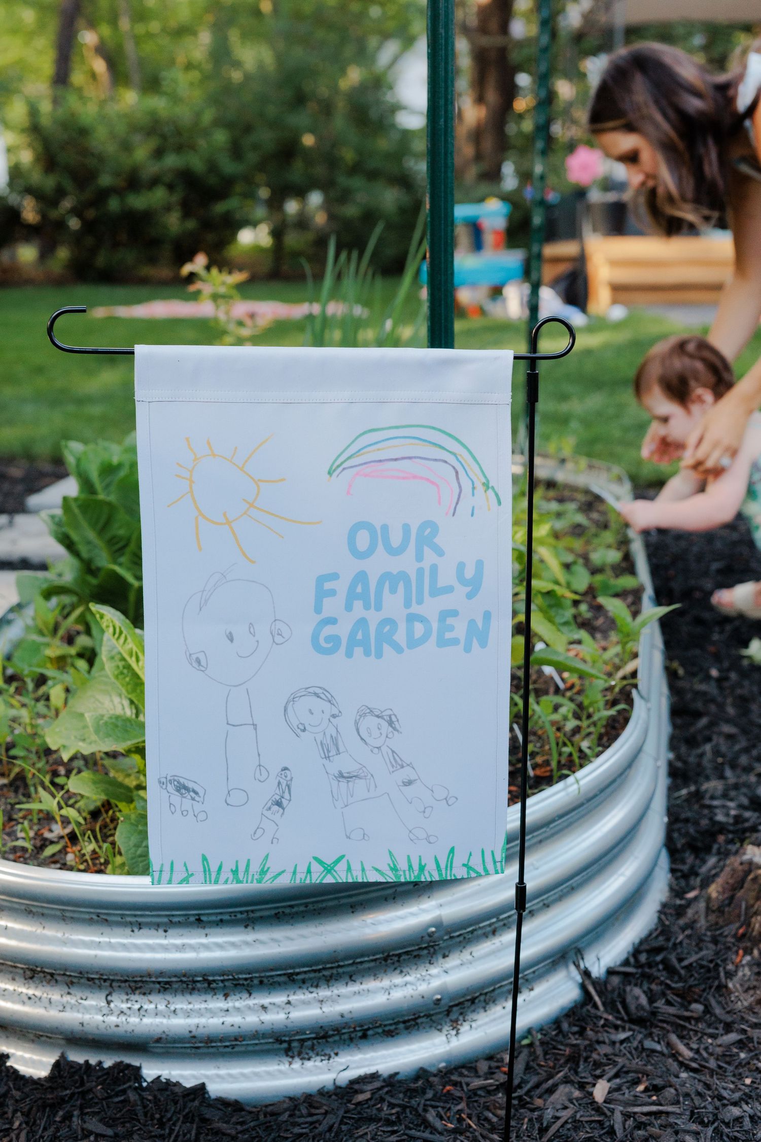 Handmade Our Family Garden flag displayed on a metal raised garden bed.