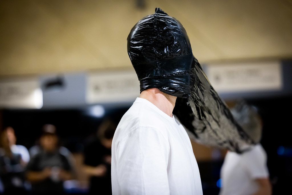 Person wearing a black plastic bag over their head as an art performance piece.