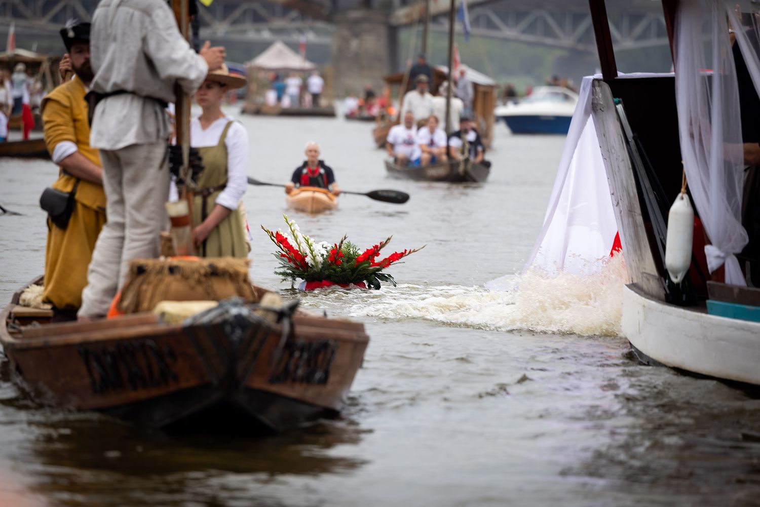 Decorated wooden boats with floral arrangements participating in a traditional river parade.