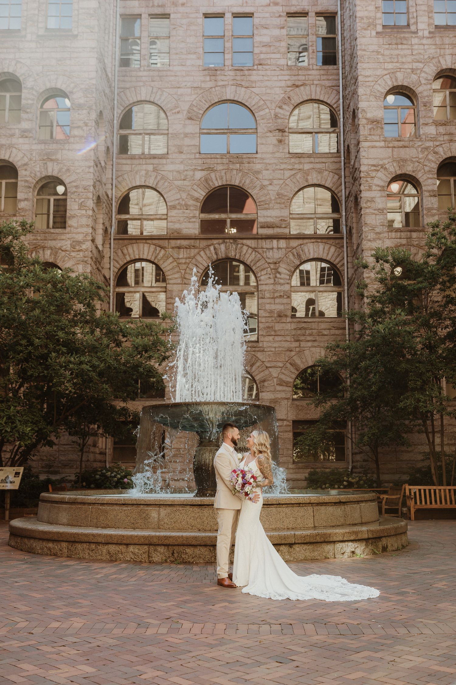 bride and groom in front of water fountain at the allegheny county courthouse, pittsburgh