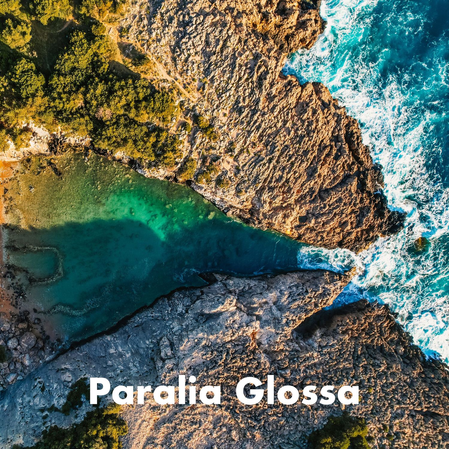 Aerial view of Paralia Glossa coastline with crystal-clear turquoise water and rugged rocky cliffs.