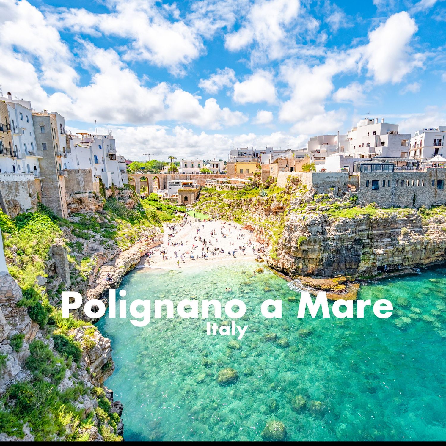 Scenic view of Polignano a Mare in Italy, with colorful cliffside buildings overlooking a turquoise cove.