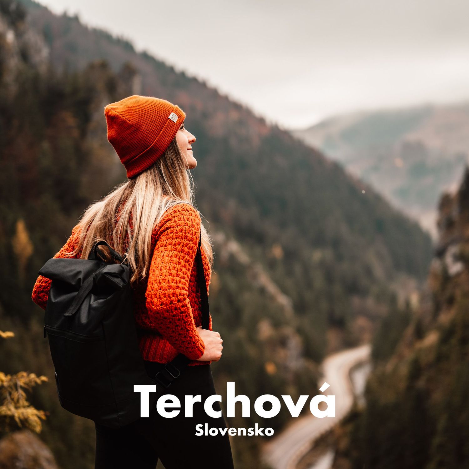 Young woman with backpack gazes at a scenic mountain valley in Terchova, Slovakia, in autumn.