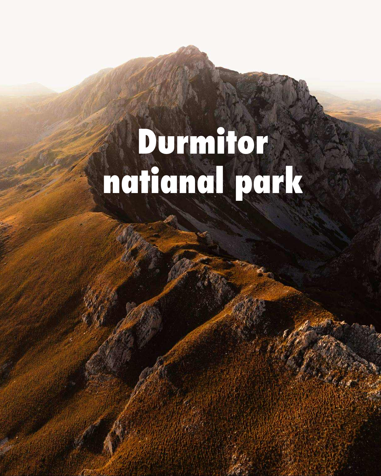 Dramatic mountain peaks of Durmitor National Park in Montenegro bathed in warm golden sunset light.