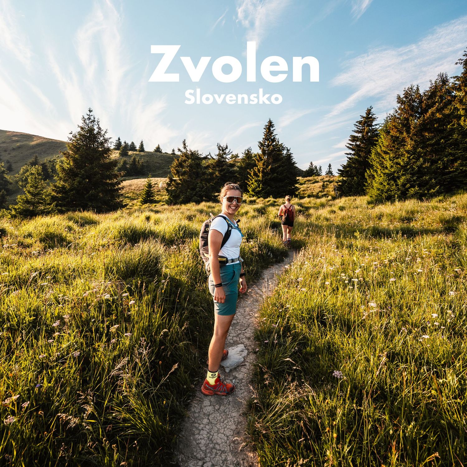 Smiling hiker on a scenic green mountain trail in Zvolen, Slovakia, on a sunny summer day.