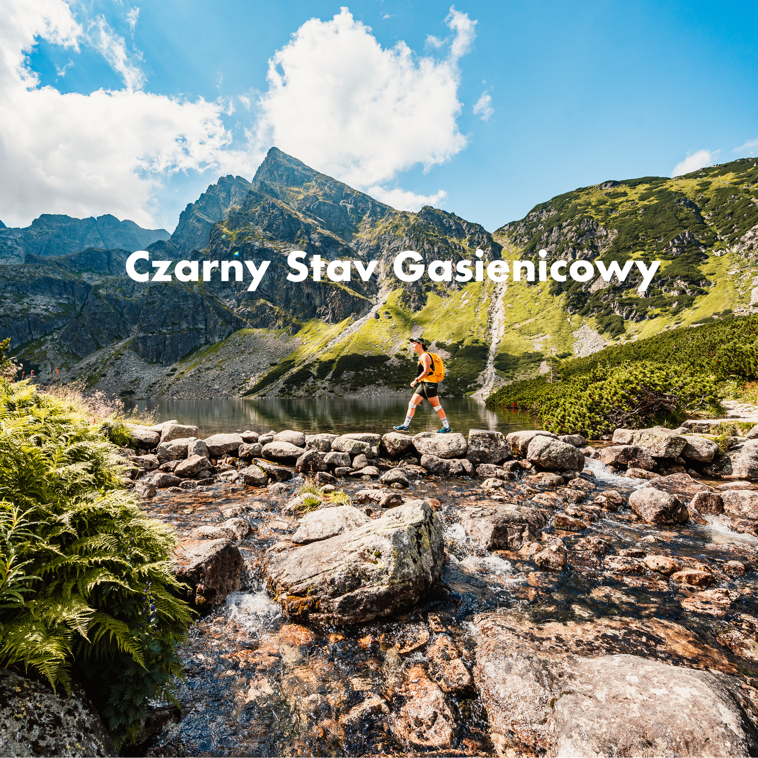 A trail runner crossing rocky terrain near Czarny Staw Gasienicowy lake in the Tatra Mountains.