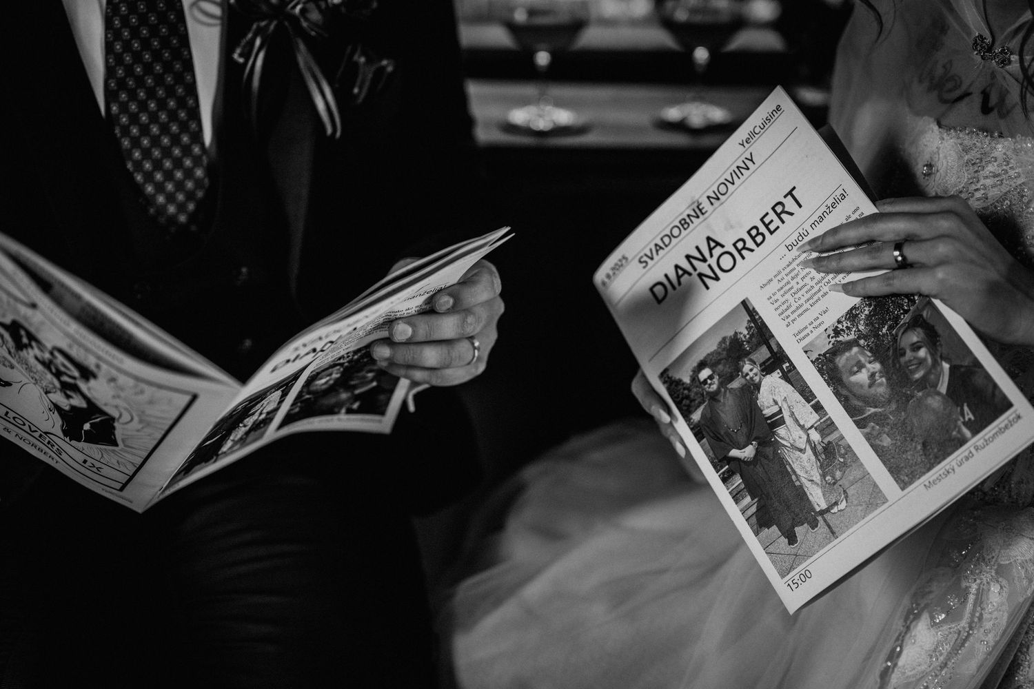 Black and white photo of bride and groom holding wedding newspapers with names Diana and Norbert at their ceremony.