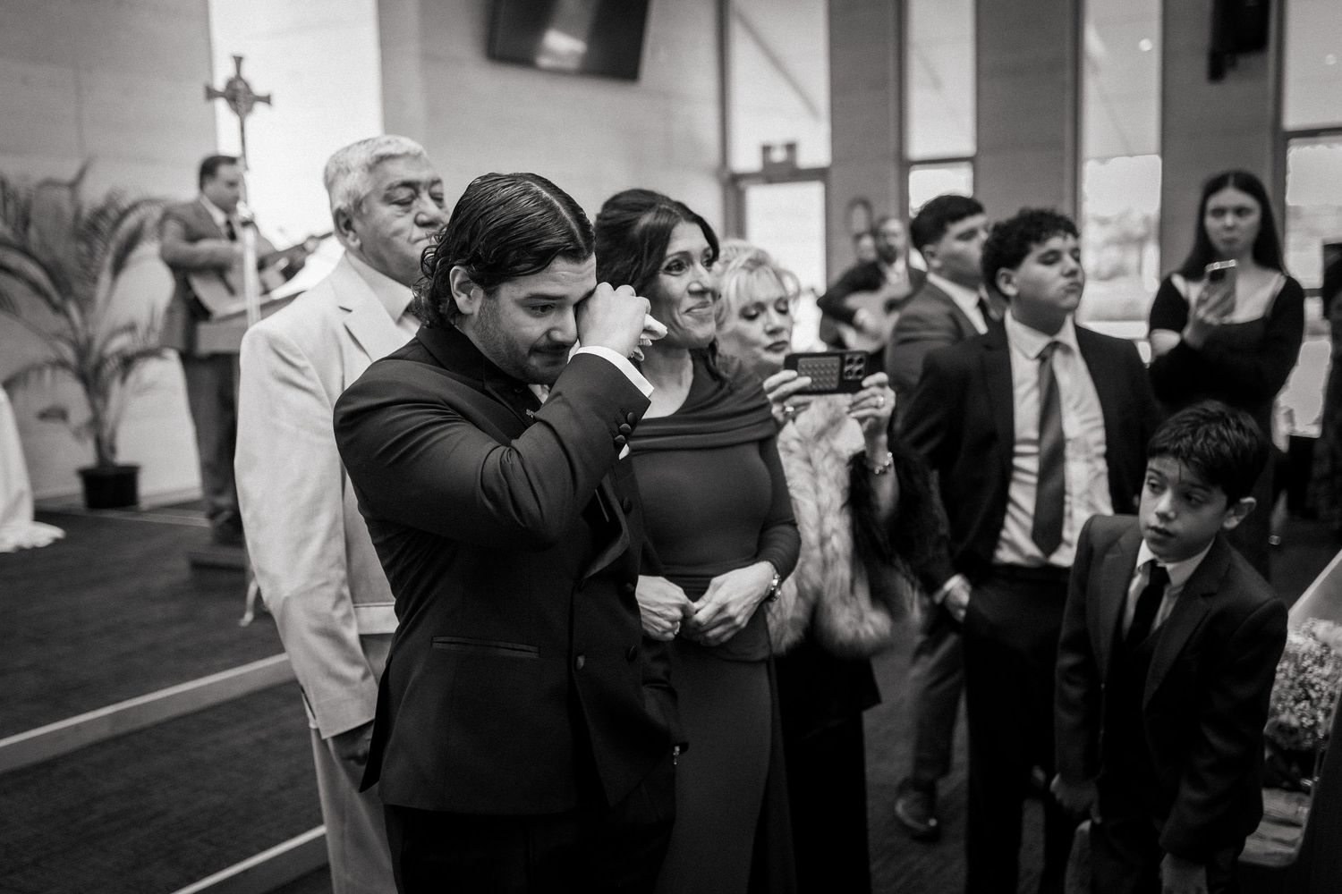 Black and white photo of elegantly dressed guests socializing at a formal wedding reception event.